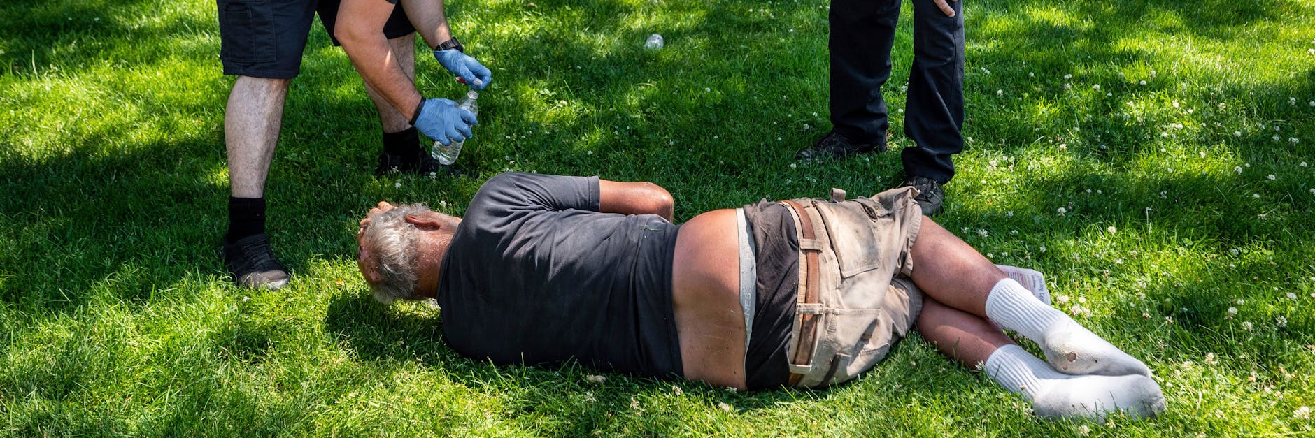 Rettungskräfte überprüfen das Wohlergehen eines Mannes im Mission Park inSPokane (US-Bundesstaat Washington). Auch in den USA wurden die höchsten Temperaturen seit dem Beginn der dortigen Aufzeichnungen im Jahr 1940 gemessen.