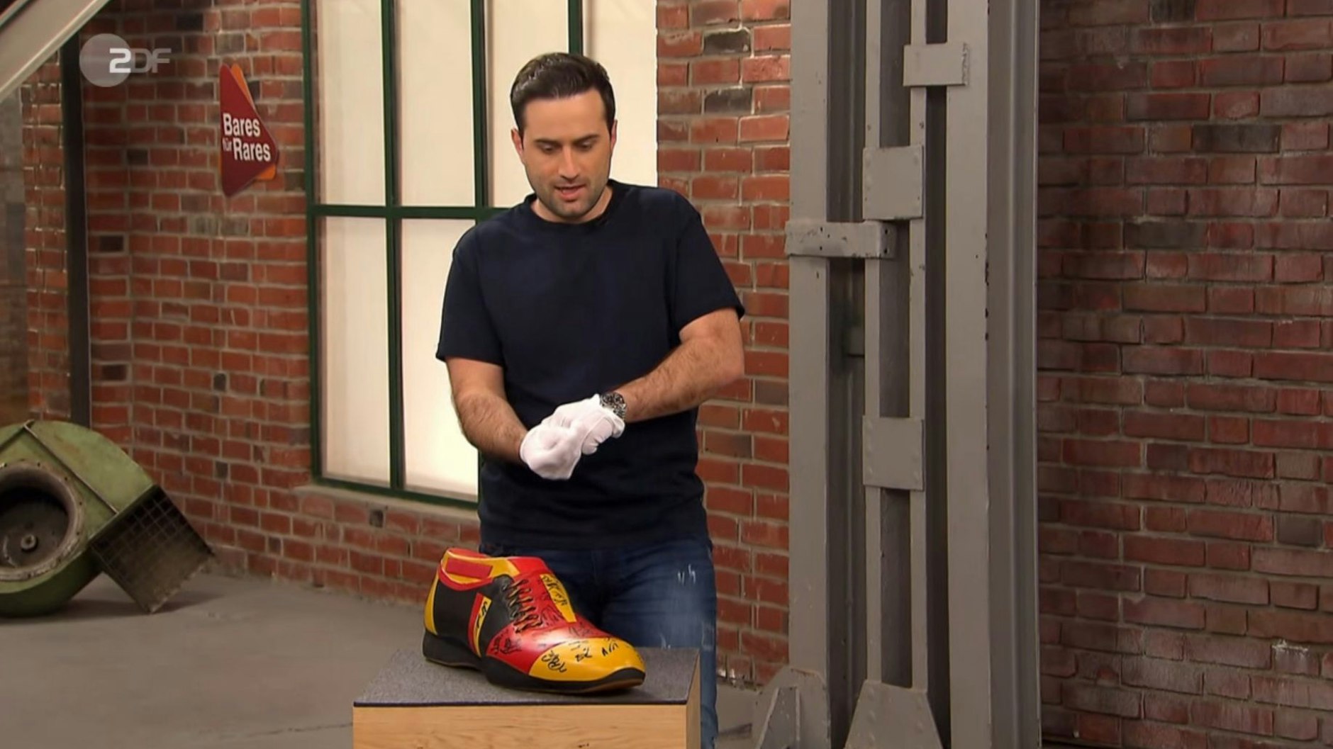 „Bares für Rares“-Händler David Suppes nimmt den großen Schuh in Augenschein.