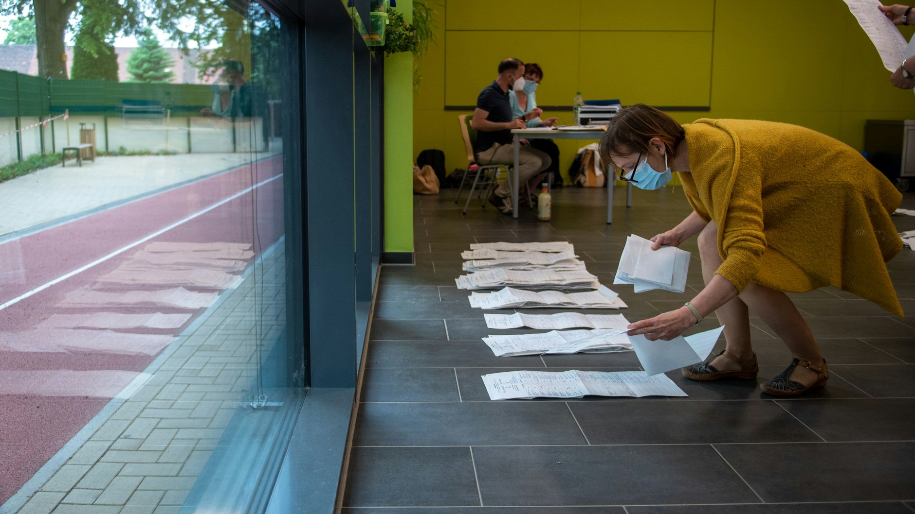 Wahlhelfer sortieren Stimmzettel in einer Schule in Magdeburg.