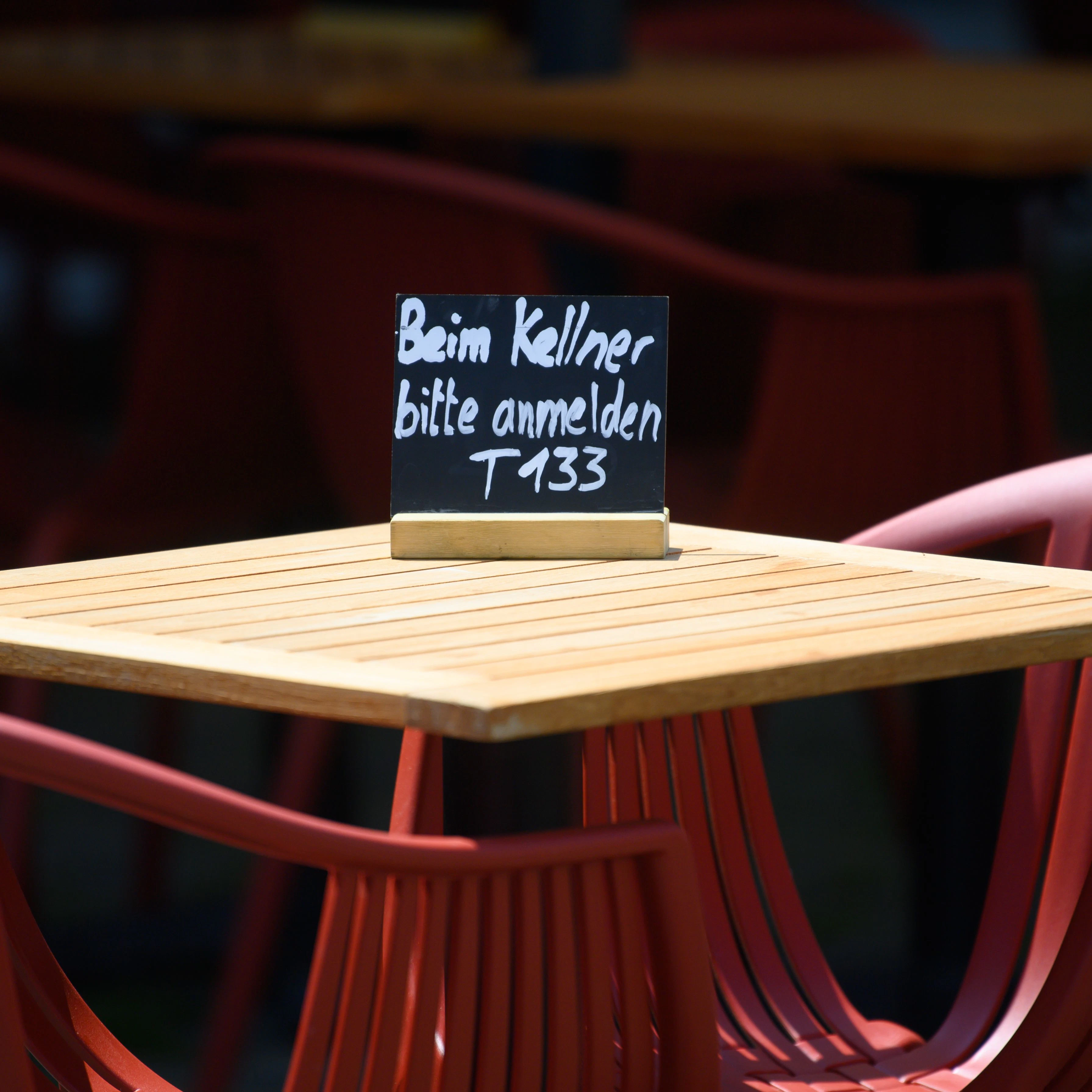Noch keine Normalität: Ein Schild „Beim Kellner bitte anmelden“ steht vor einem Restaurant.