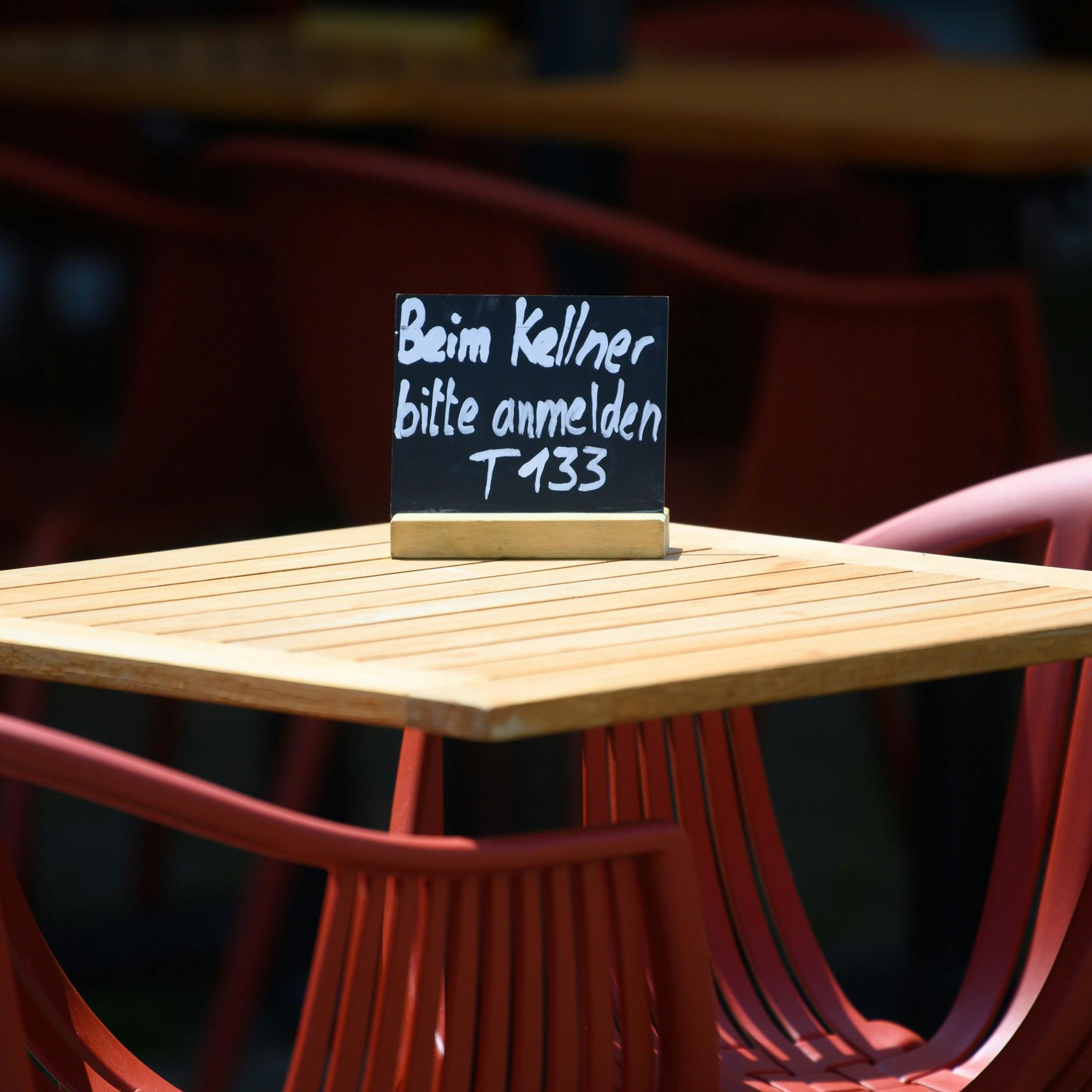 Noch ist die Normalität nicht wieder da: Ein Schild „Beim Kellner bitte anmelden“ steht vor einem Restaurant.