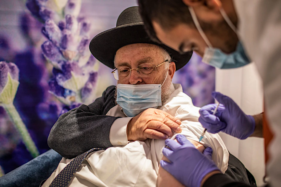 Israel: Ein Mann erhält im Rahmen einer landesweiten Impfkampagne eine Dosis des Corona-Impfstoffs von Biontech/Pfizer. Trotz hoher Impfquote steigen die Corona-Neuinfektionen wieder an.