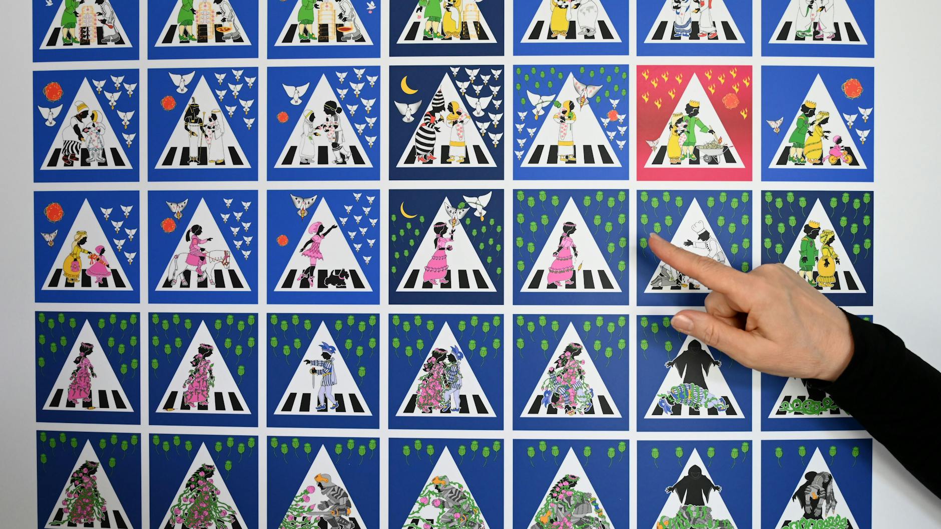 Die Kasseler Künstlerin Doris Gutermuth zeigt in ihrem Atelier auf ein Tableau von Zebrastreifenschildern mit Dornröschen-Motiven. 