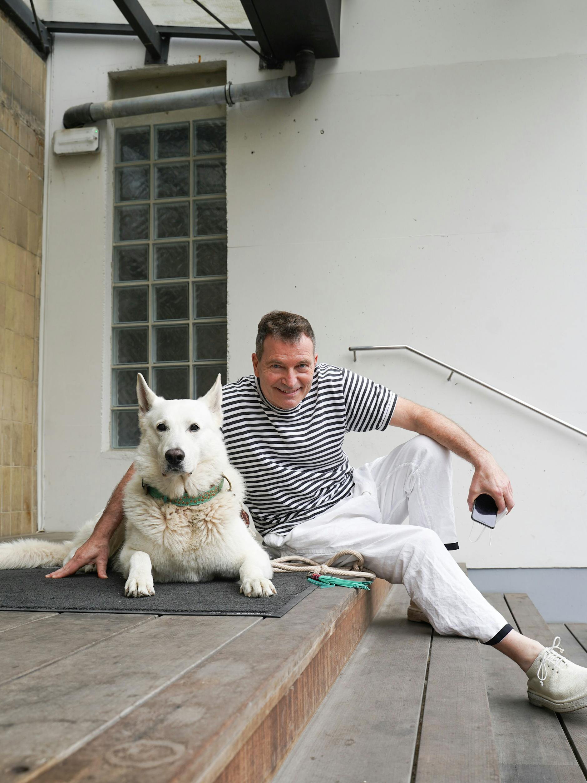 Jürgen betreibt die Kosmetikfirma Beauty Punch. Nach einem Friseurbesuch bummelt er mit Cooper, einem wunderschönen Canadian Shepherd, noch ein wenig in der Gegend herum und schaut mal bei Murkudis vorbei. Er trägt ein Shirt von Comme des Garçons, dazu eine weiße Leinenhose sowie Lederschuhe von Marsèll. 