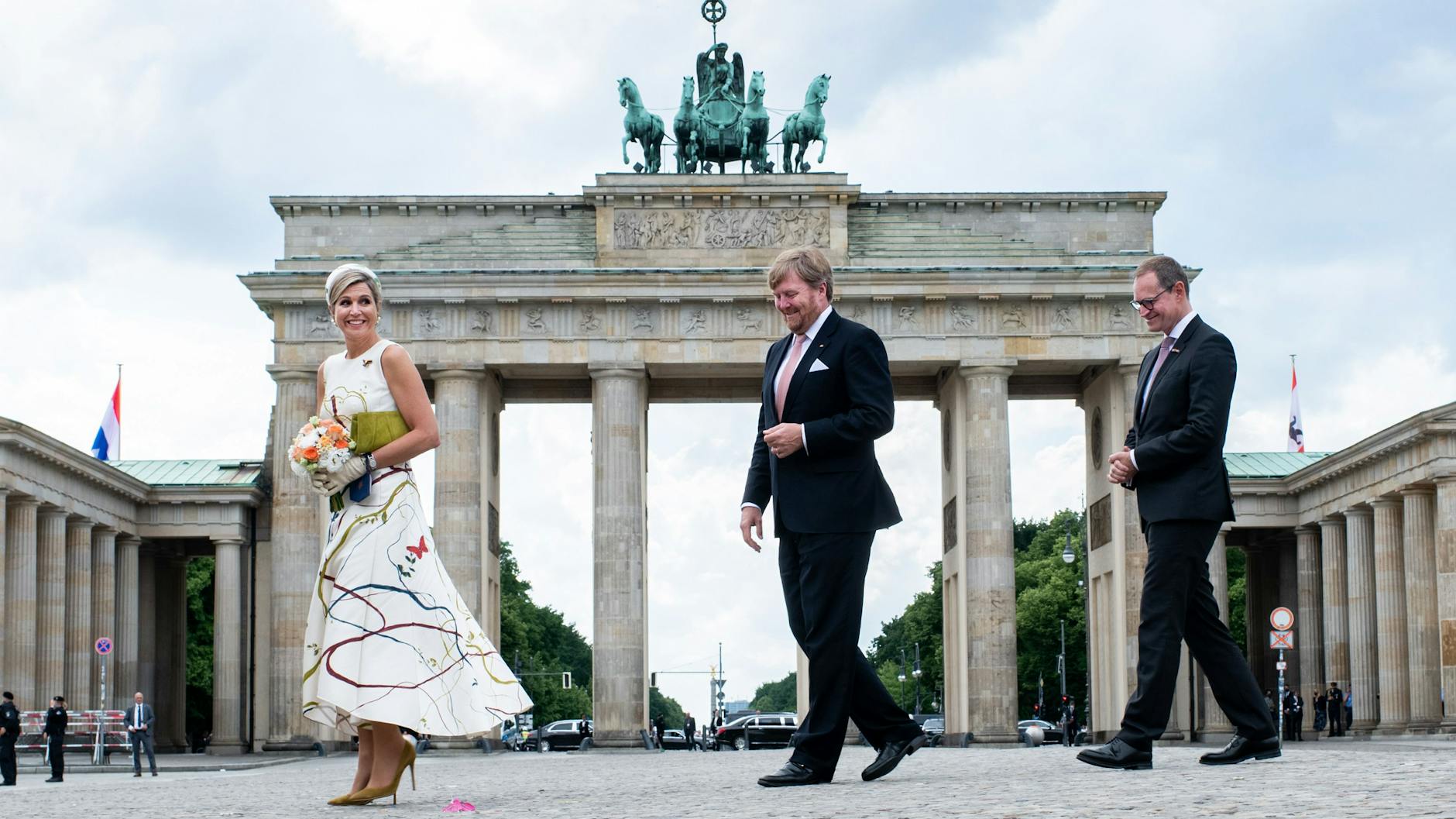 Willem-Alexander und Maxima gehen zusammen mit dem Regierenden Bürgermeister Michael Müller (SPD) über den Pariser Platz vor dem Brandenburger Tor.