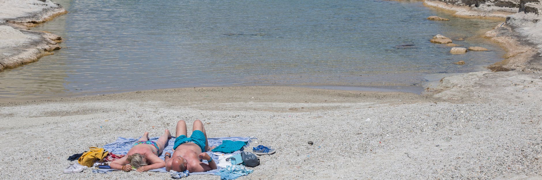 Menschen sonnen sich am Strand von Sarakiniko auf der griechischen Insel Milos.