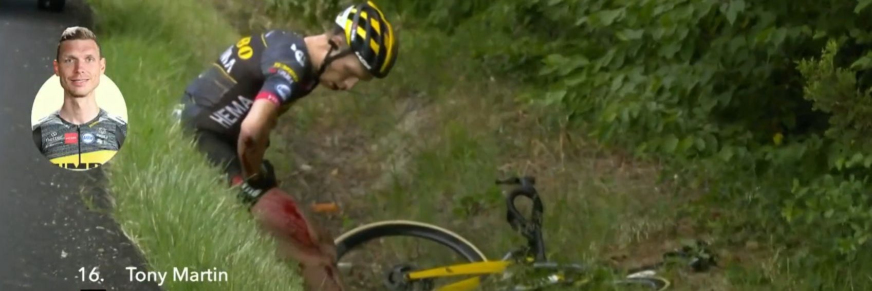 Der gestürzte Tony Martin sitzt schwer verletzt im Straßengraben.