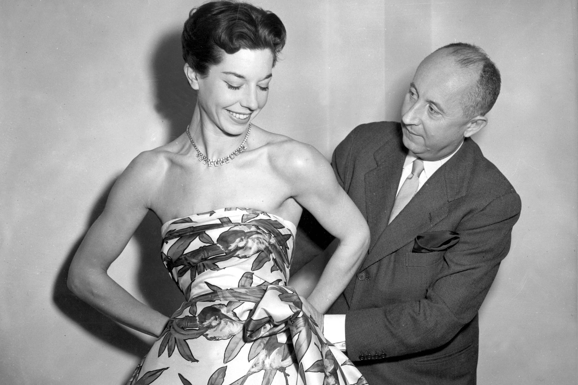 Christian Dior bei einer Anprobe mit Model Dorothy Emms, 1952.