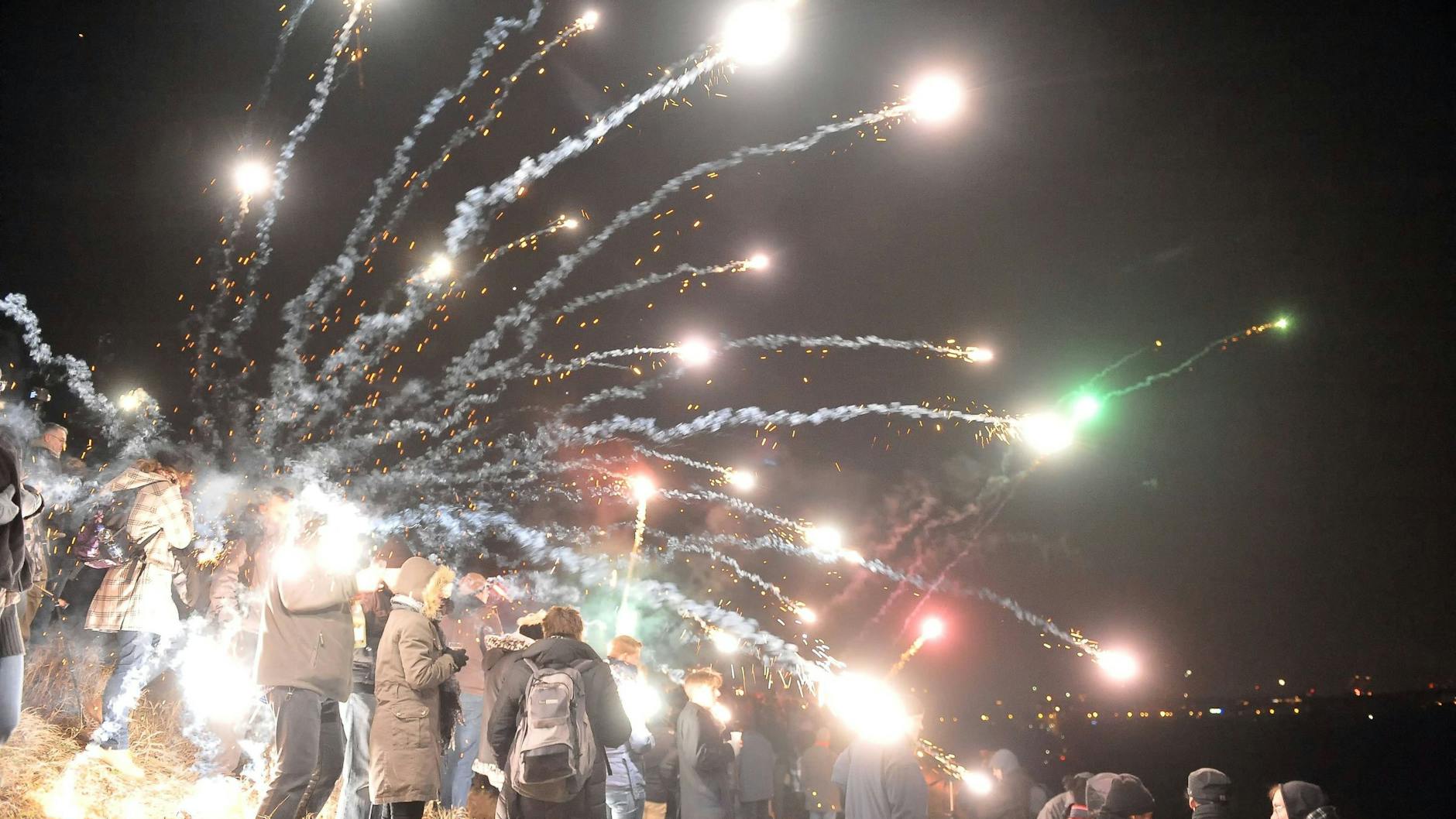 Menschen zünden zum Jahreswechsel in Berlin Feuerwerk (Symbolbild).