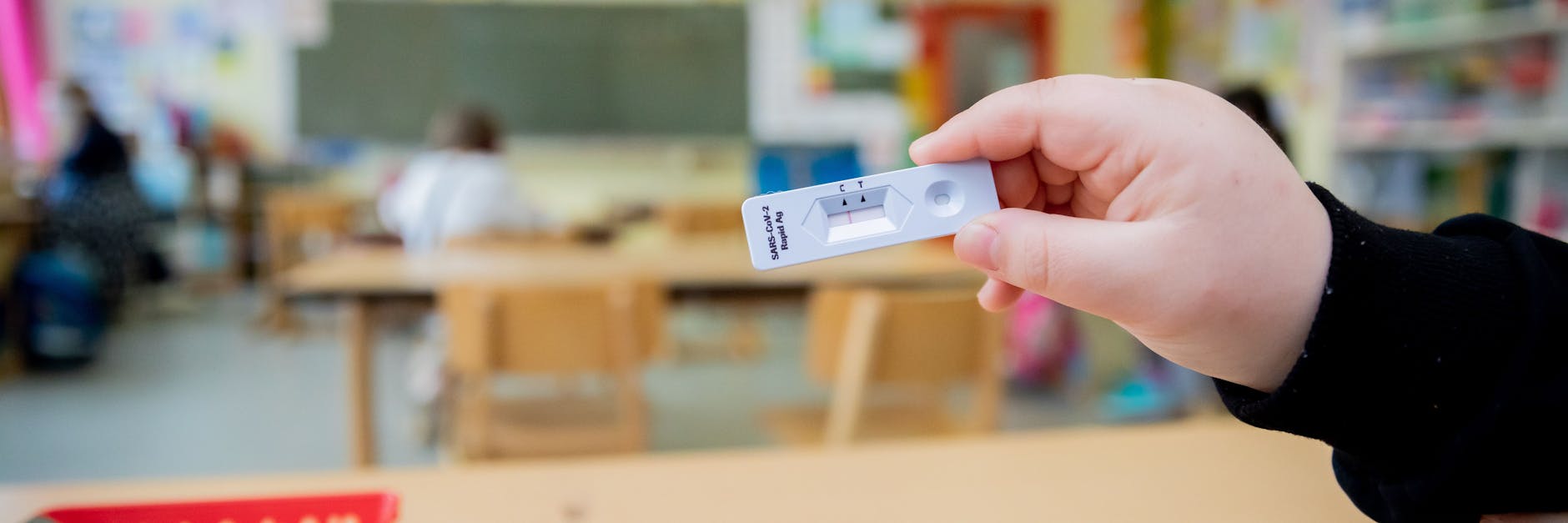 Ein Schüler hält bei einem Probelauf mit Corona-Schnelltests an der Grundschule in der Köllnischen Heide in Berlin-Neukölln seinen negativen Test in die Kamera. 