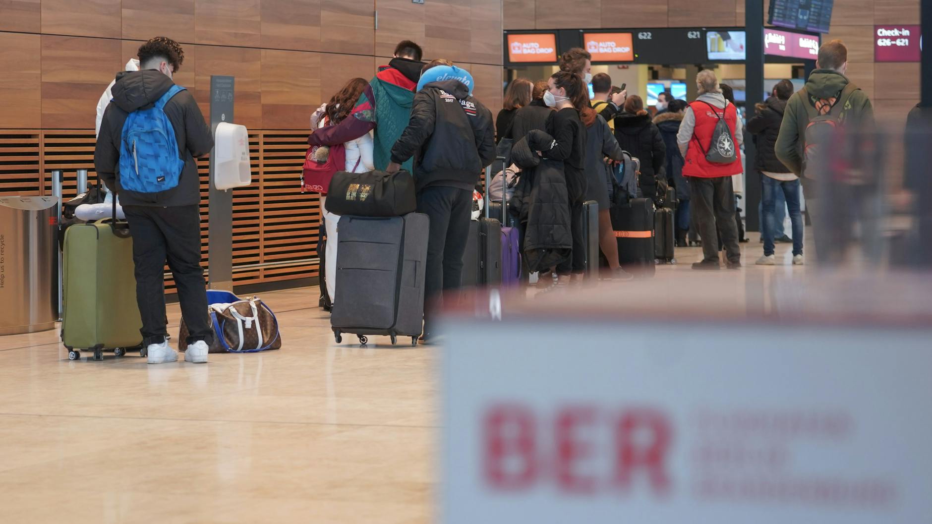 Der Flughafen BER am 2. Januar 2022: Reisende stehen mit Koffern in einer Warteschlange an einem Check-in-Schalter.