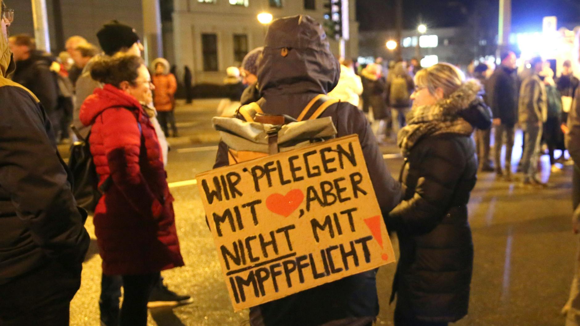 Rostock: Gegner einer Corona-Impfpflicht ziehen mit Plakaten durch die Innenstadt.