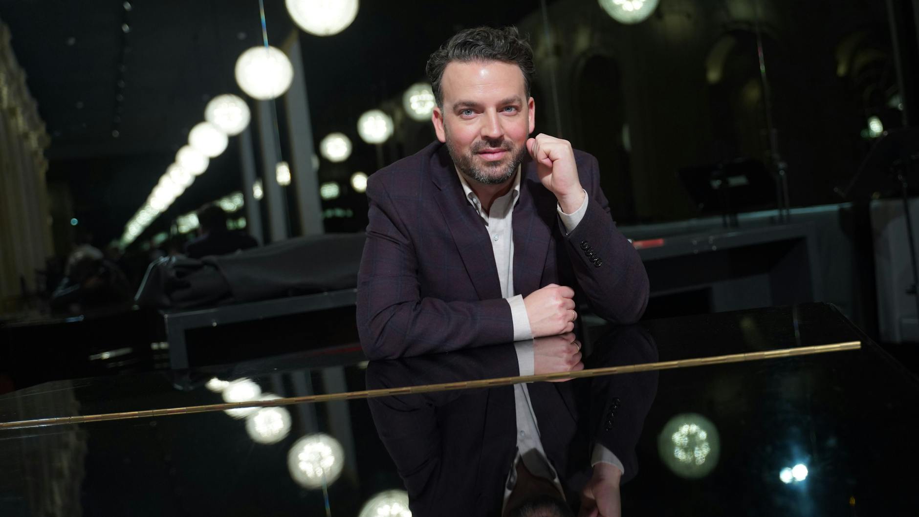 James Gaffigan, neuer Generalmusikdirektor der Komischen Oper, sitzt an einem Flügel.