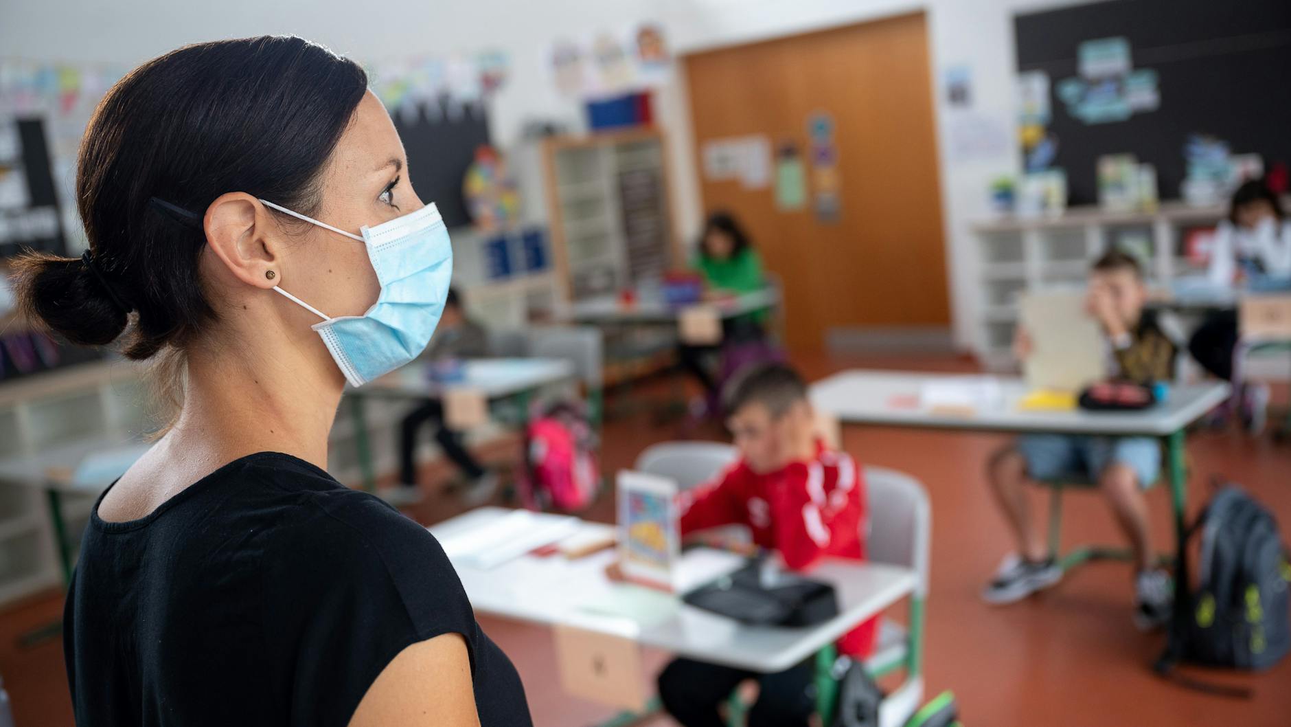Eine Lehrerin steht in einer Grundschule. Die Kultusministerkonferenz bleibt bei ihrer Linie, Schulen trotz Corona offen zu halten.
