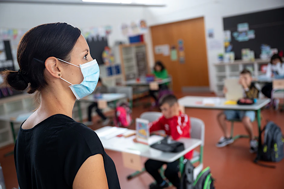 Eine Lehrerin steht in einer Grundschule. Die Kultusministerkonferenz bleibt bei ihrer Linie, Schulen trotz Corona offen zu halten.