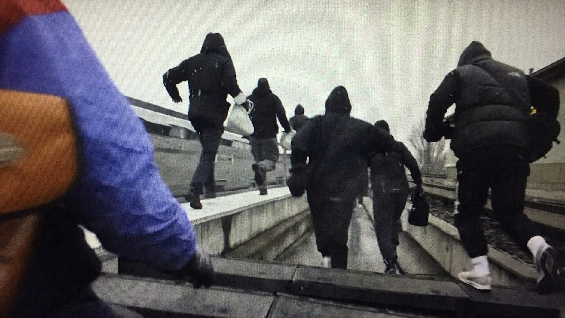 Nach der Tat hauen die Sprayer von 1UP über die Gleisanlagen ab.