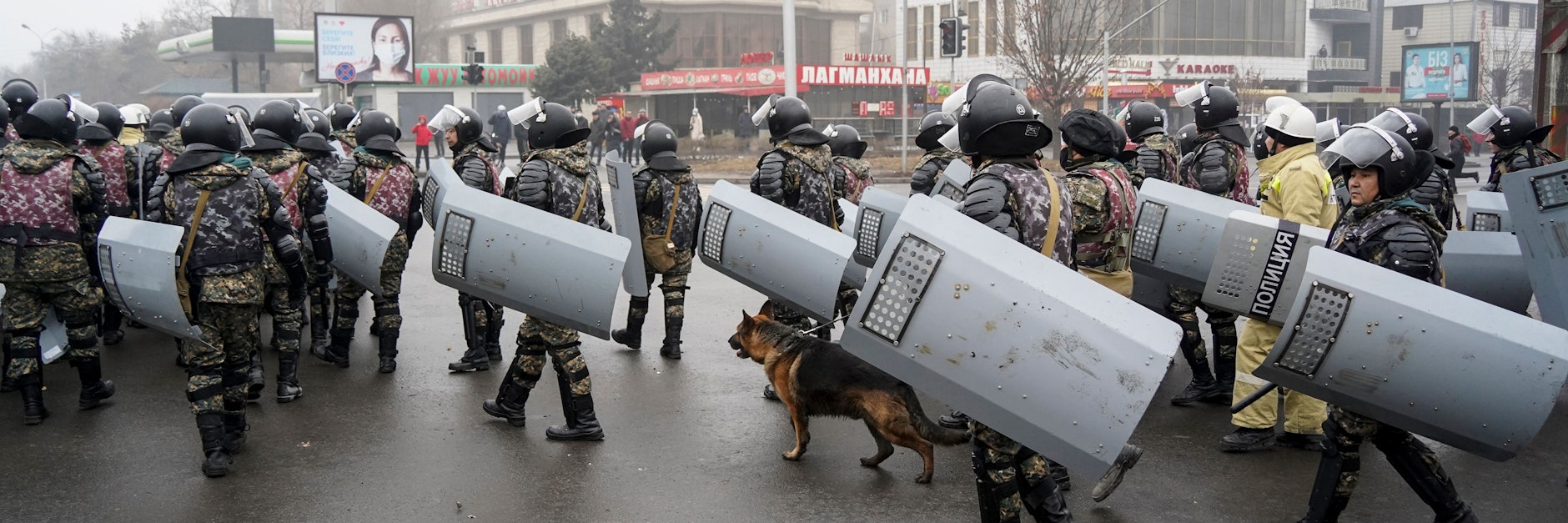 Polizisten stellen sich in Almaty Demonstranten entgegen.