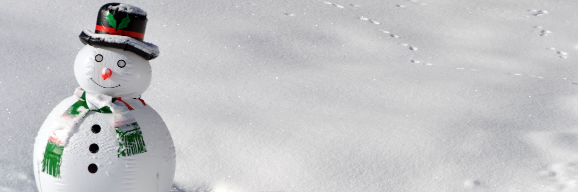 Ein aufblasbarer Schneemann steht im Schnee.