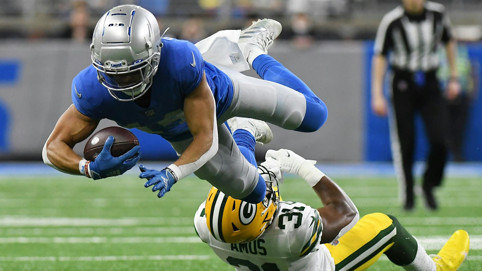 Detroit Lions Wide Receiver Amon-Ra St. Brown fliegt über Safety Adrian Amos von den Green Bay Packers.