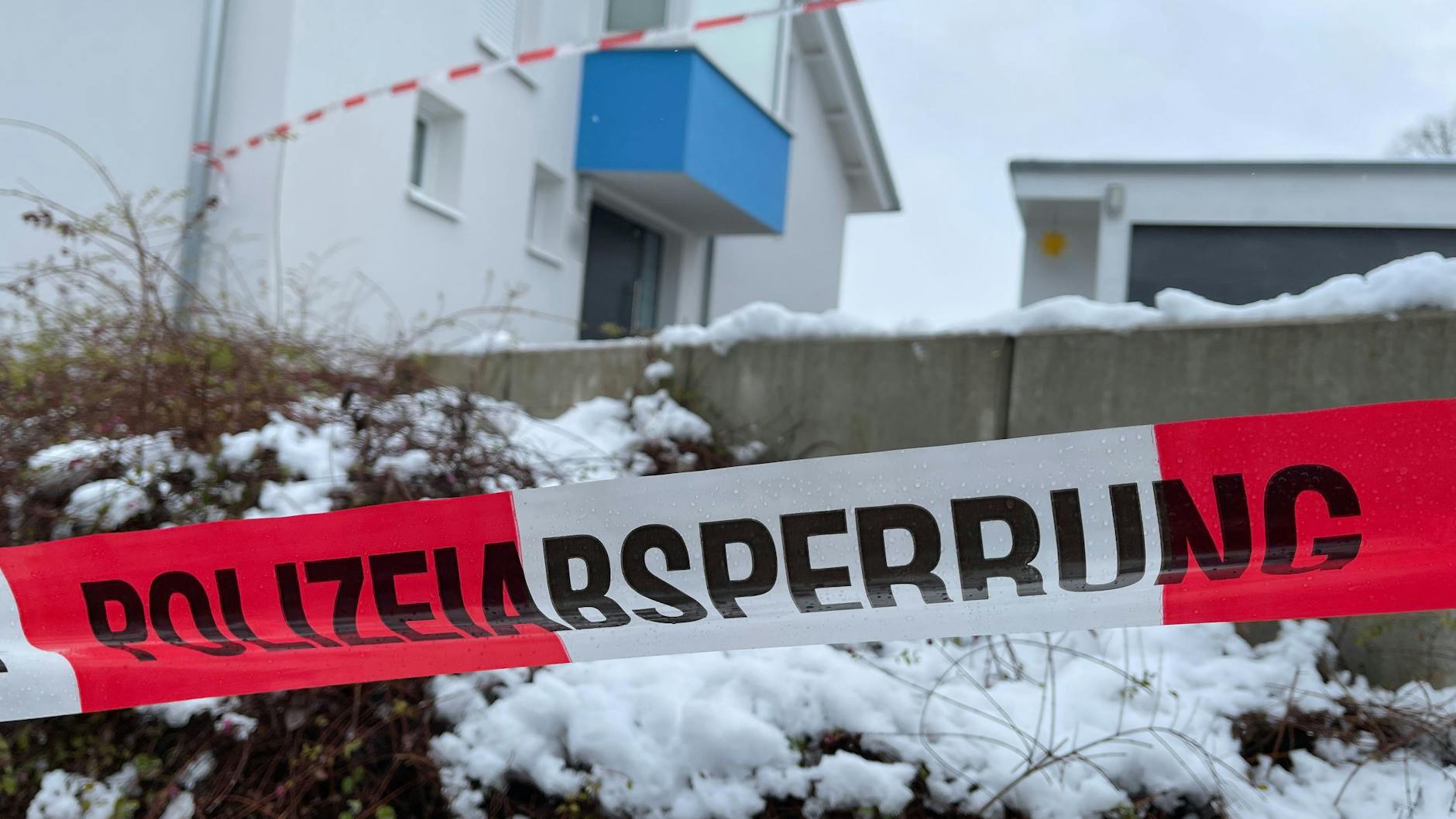 Ein Absperrband der Polizei ist vor einem Einfamilienhaus gespannt. Ein 18-Jähriger soll die Eltern seiner Freundin getötet haben.
