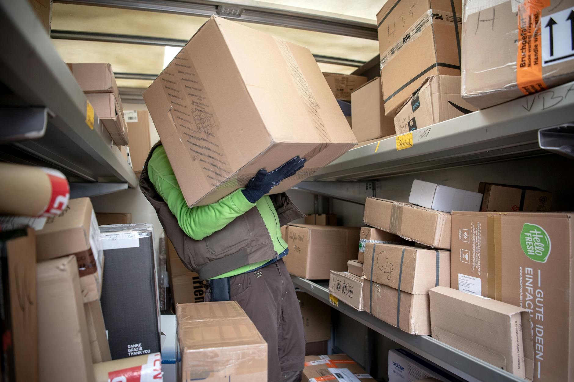 Ein Paketbote lädt Pakete in einen Transporter.