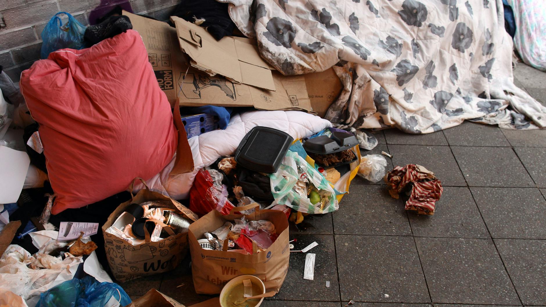 Unter der Brücke liegen jede Menge Unrat und persönliche Gegenstände.
