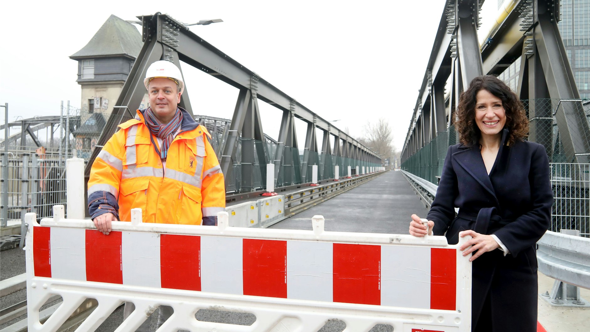 Gleich rollt der Verkehr über die provisorische Elsenbrücke. Berlins Brückenbauchef Arne Huhn und die&nbsp; Senatorin für Mobilität, Bettina Jarasch, räumen die Sperre weg.