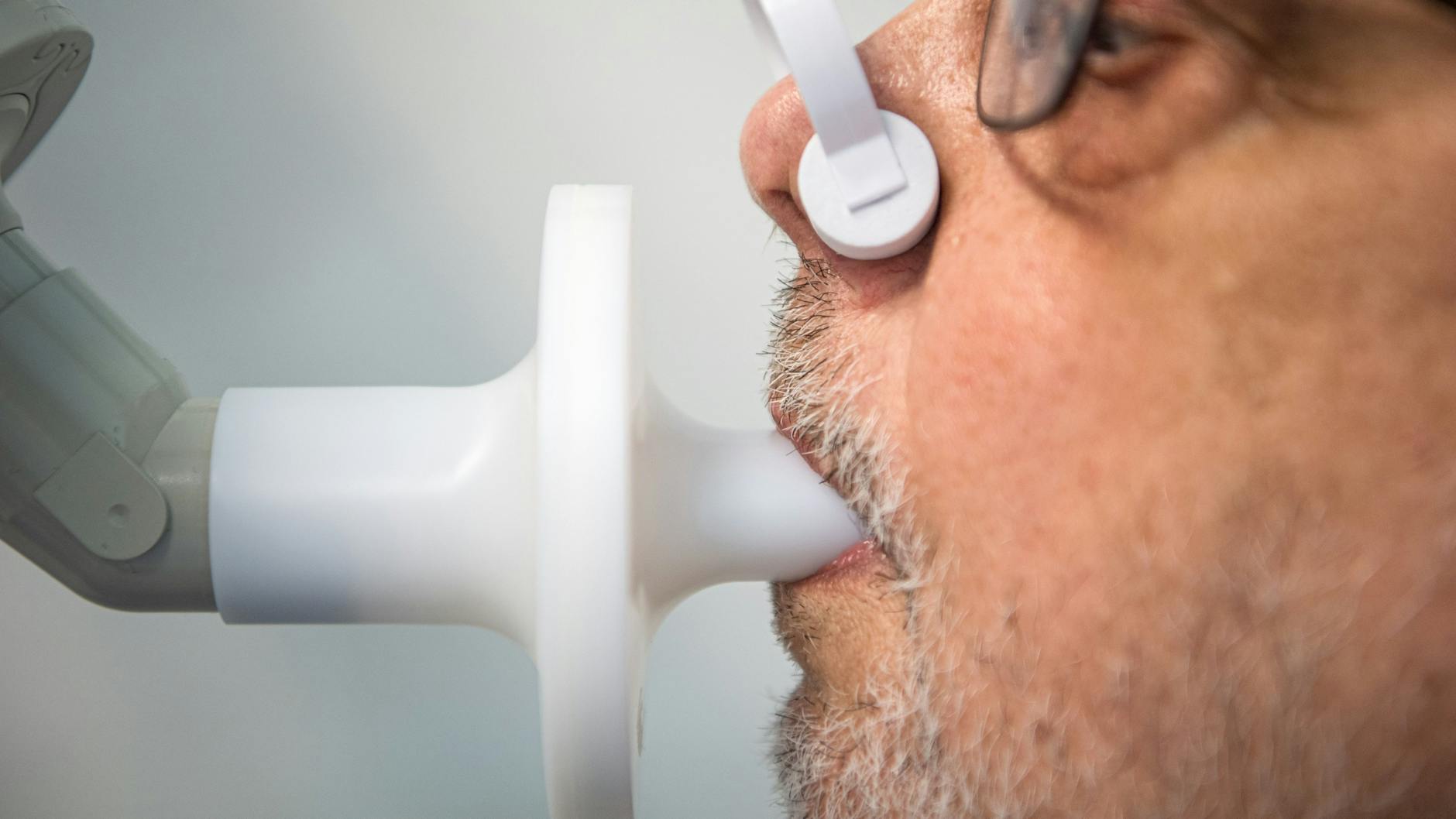 Ein Patient sitzt in einer Klinik am Teutoburger Wald, in der Long-Covid-Patienten behandelt werden, zur Überprüfung seiner Lungenfunktion in einem Bodyplethysmographen.