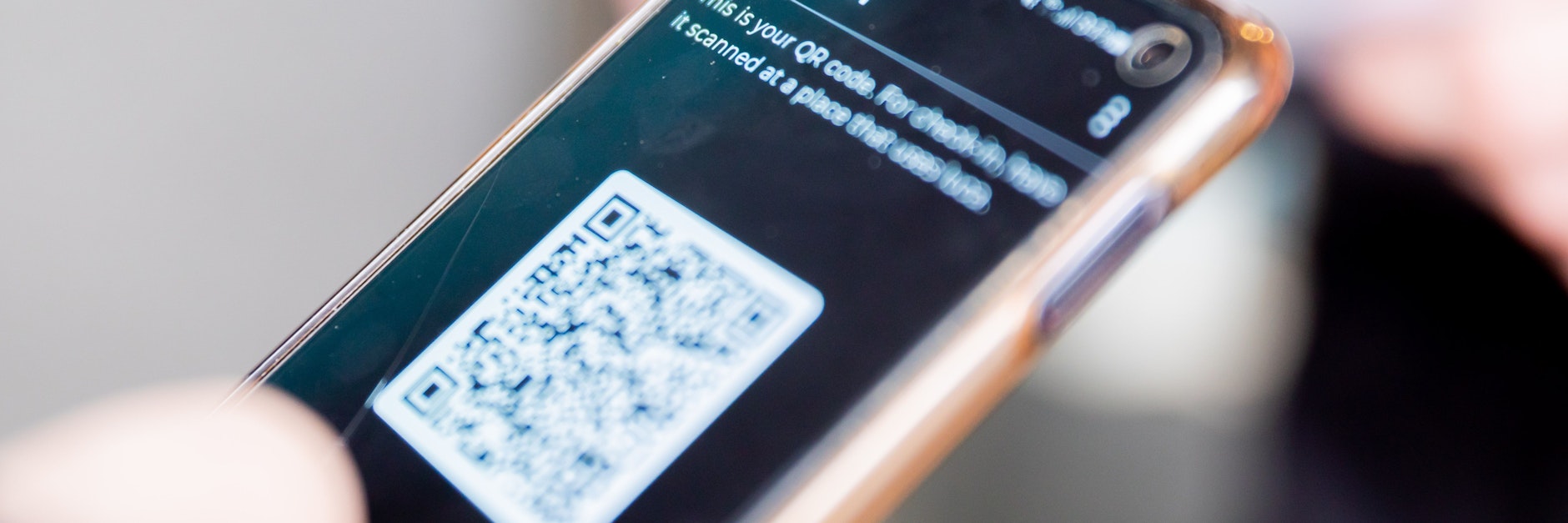Check-in am Eingang eines Bekleidungsgeschäftes: in der Luca-App einer Person