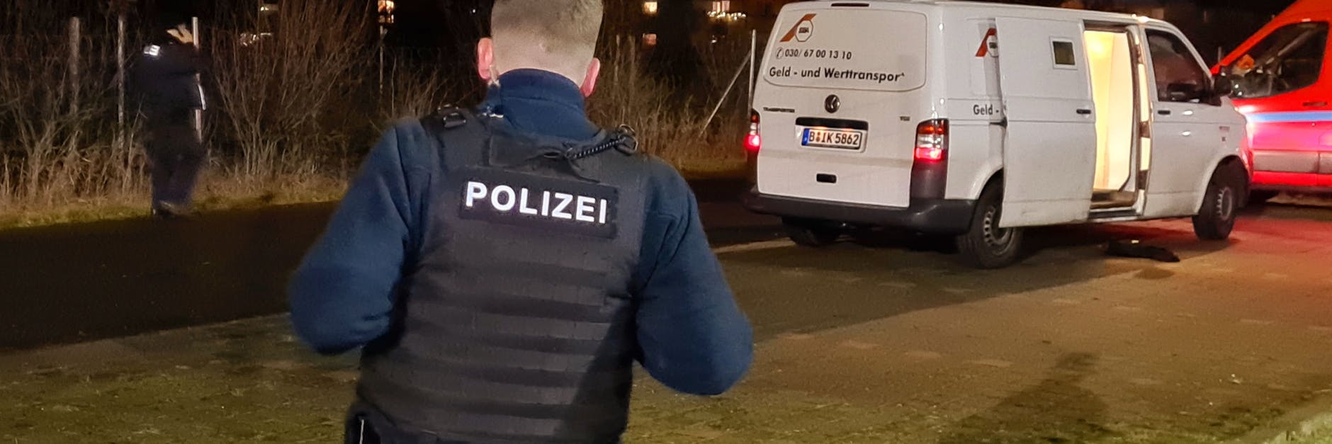 Ein Polizist steht vor einem geöffneten Geldtransporter, der überfallen worden ist. Das Fahrzeug stand laut Polizei vor einem Supermarkt, als die Täter den Fahrer aufforderten, auf eine bestimmte Straße zu fahren. 
