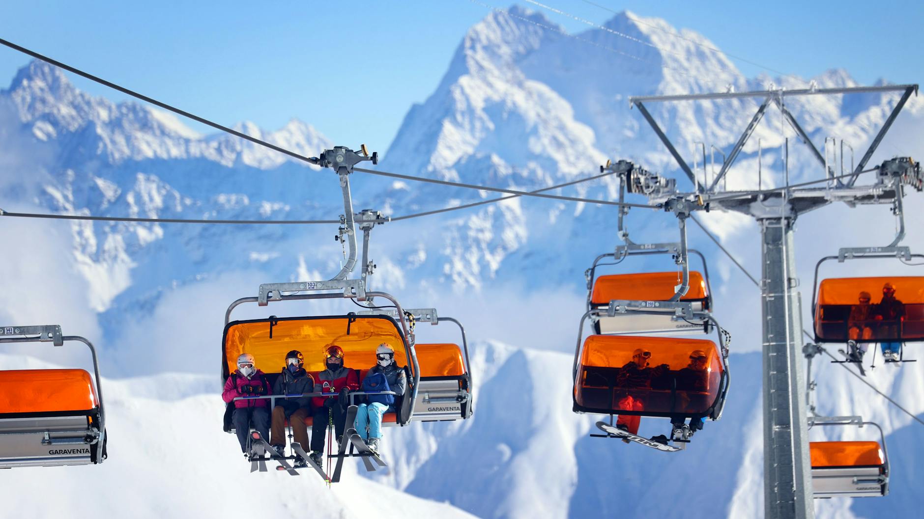 Ischgl: Skifahrer sitzen im Skigebiet Ischgl in einem Sessellift. Österreich ist ab Sonntag wieder Hochrisikogebiet.