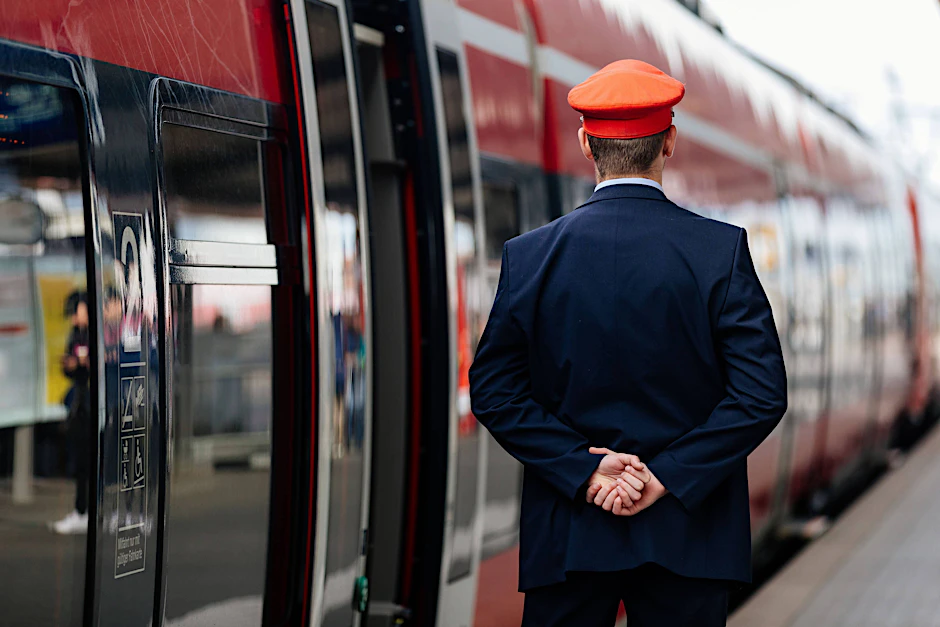 Ein Schaffner der Deutschen Bahn steht auf einem Bahnsteig (Symbolbild). Da bei dem Konzern Tausende Mitarbeiter aus Altersgründen ausscheiden, müssen jedes Jahr zahlreiche Stellen nachbesetzt werden.