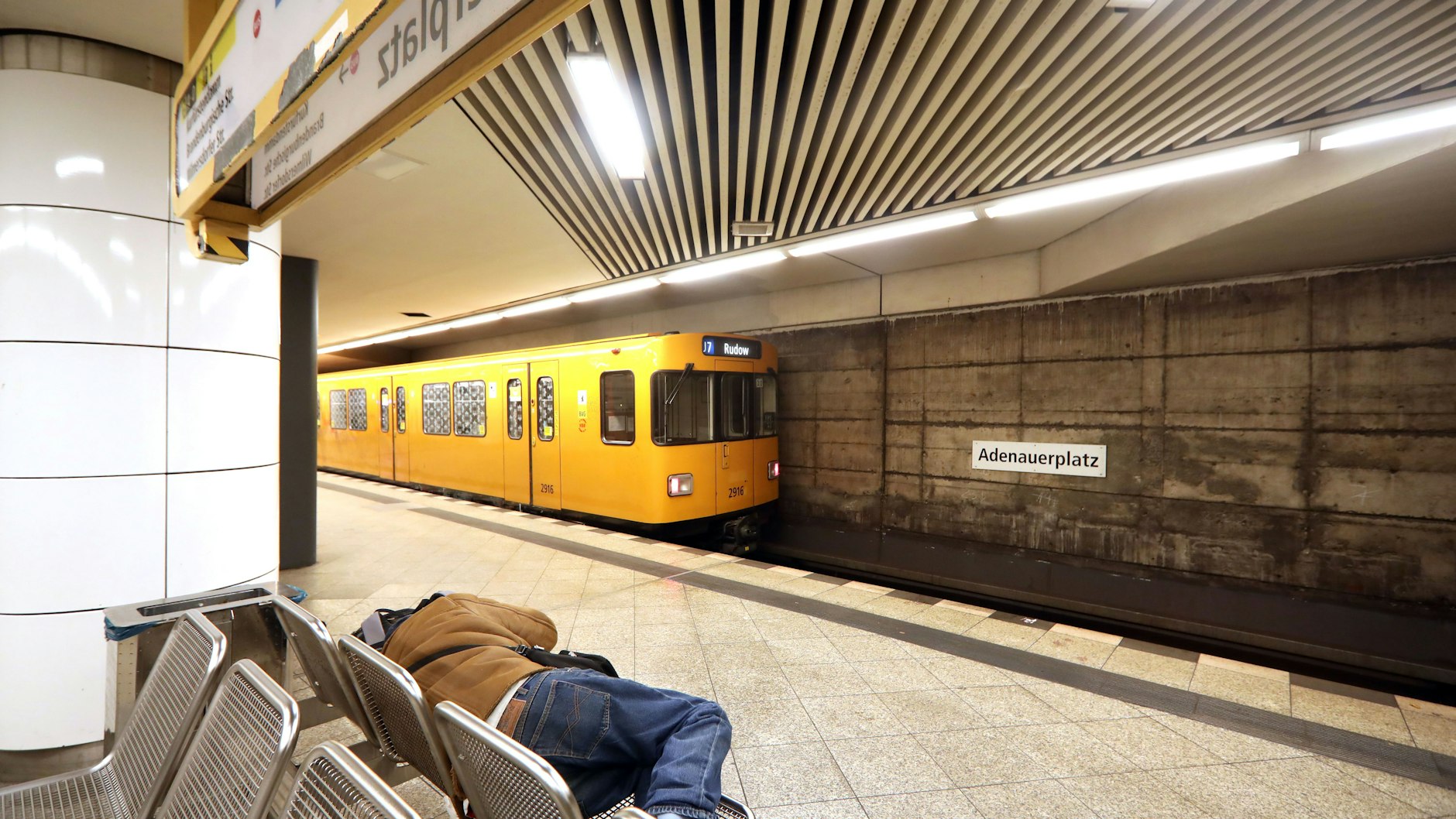 Ein Mann schläft im U-Bahnhof Adenauerplatz in Charlottenburg. Auch in der Station an der U7, die 1978 ans Netz ging, schauen die Nutzer auf nackte Betonwände.