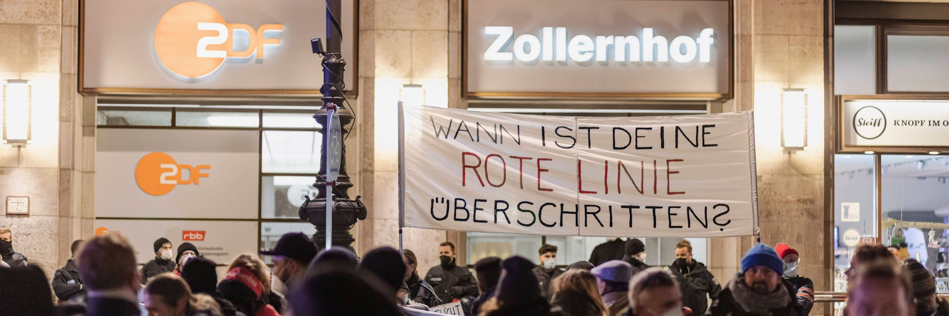 Das Ziel einer Demonstration war das ZDF-Hauptstadtstudio und eine dortige Protestkundgebung. Demonstrationsteilnehmer halten ein Spruchband hoch mit der Aufschrift: Wann ist deine Rote Linie überschritten?