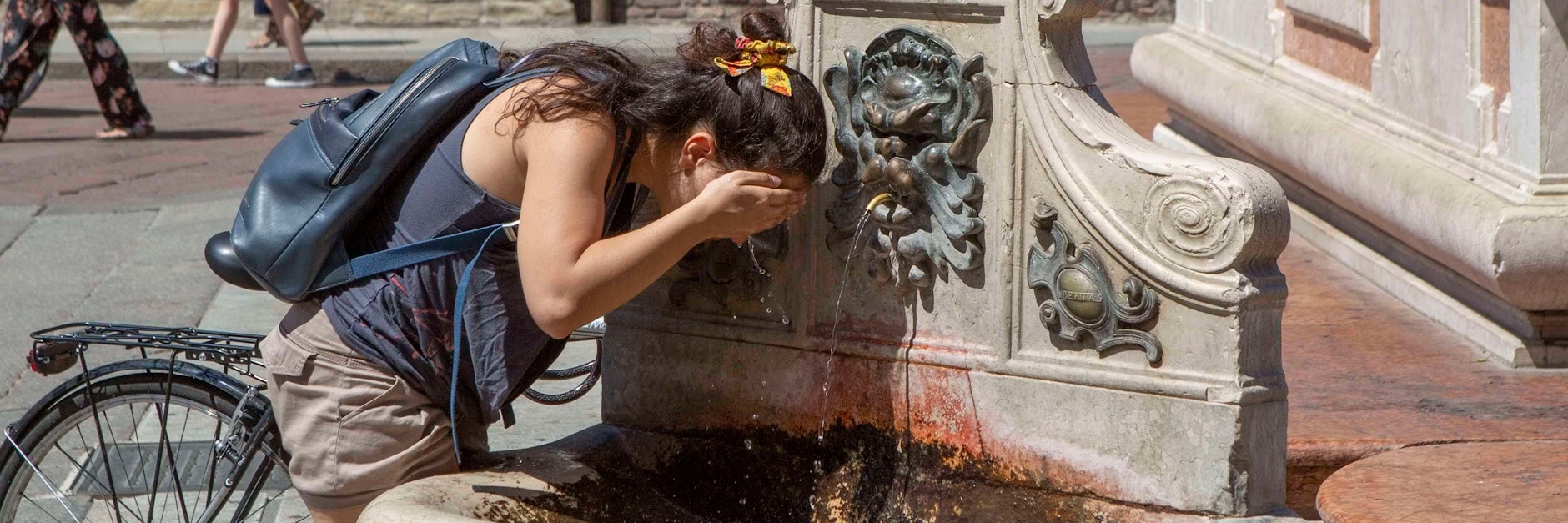 Eine Frau erfrischt sich im italienischen Bologna einem Brunnen. Das vergangene Jahr war das siebte Jahr in Folge mit Temperaturen, die mehr als ein Grad über dem vorindustriellen Niveau lagen, so die Weltwetterorganisation WMO.&nbsp;&nbsp;
