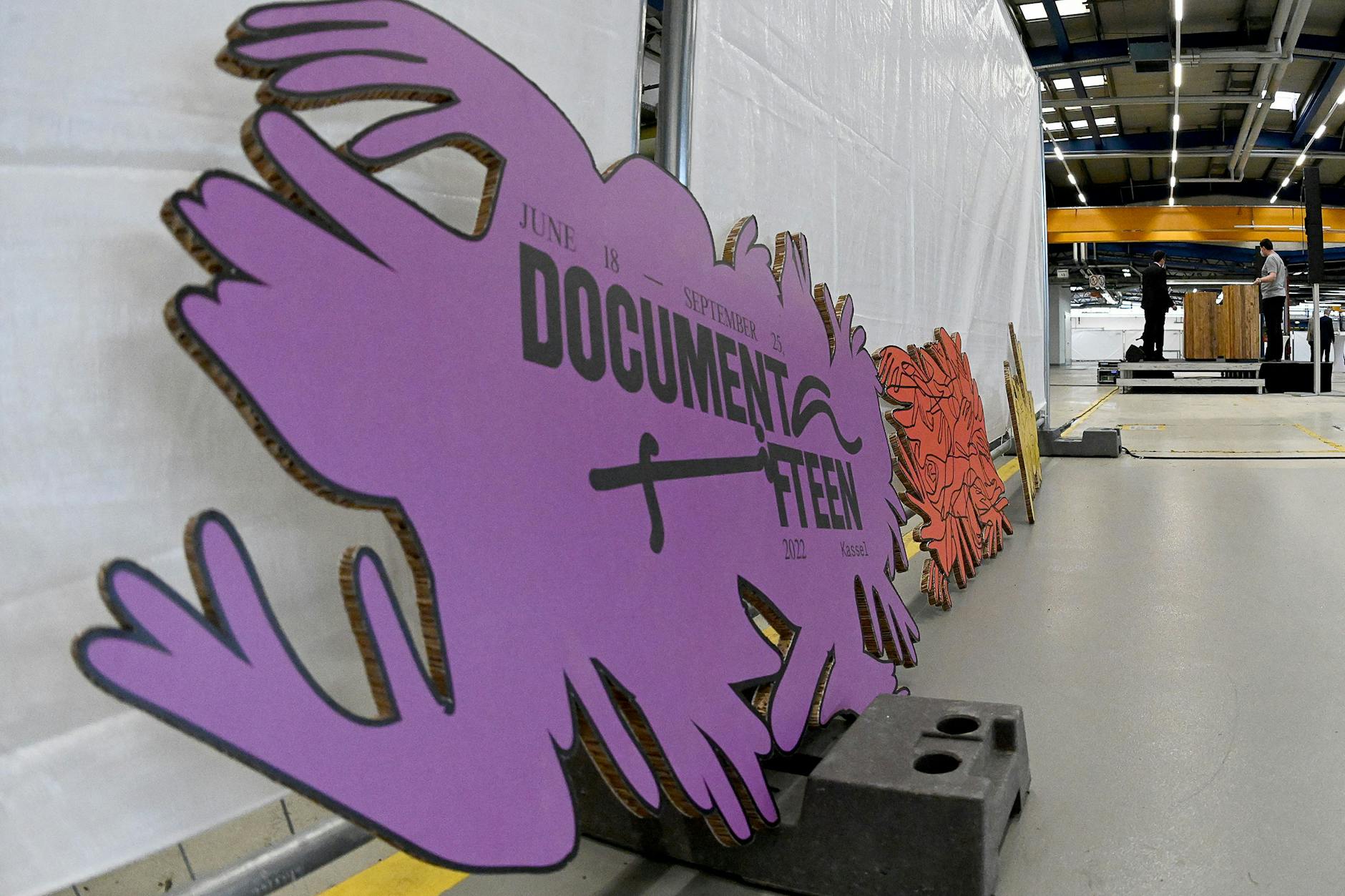 Das Logo der Documenta 15 lehnt an einem Bauzaun im neuen Standort für die Documenta f15.