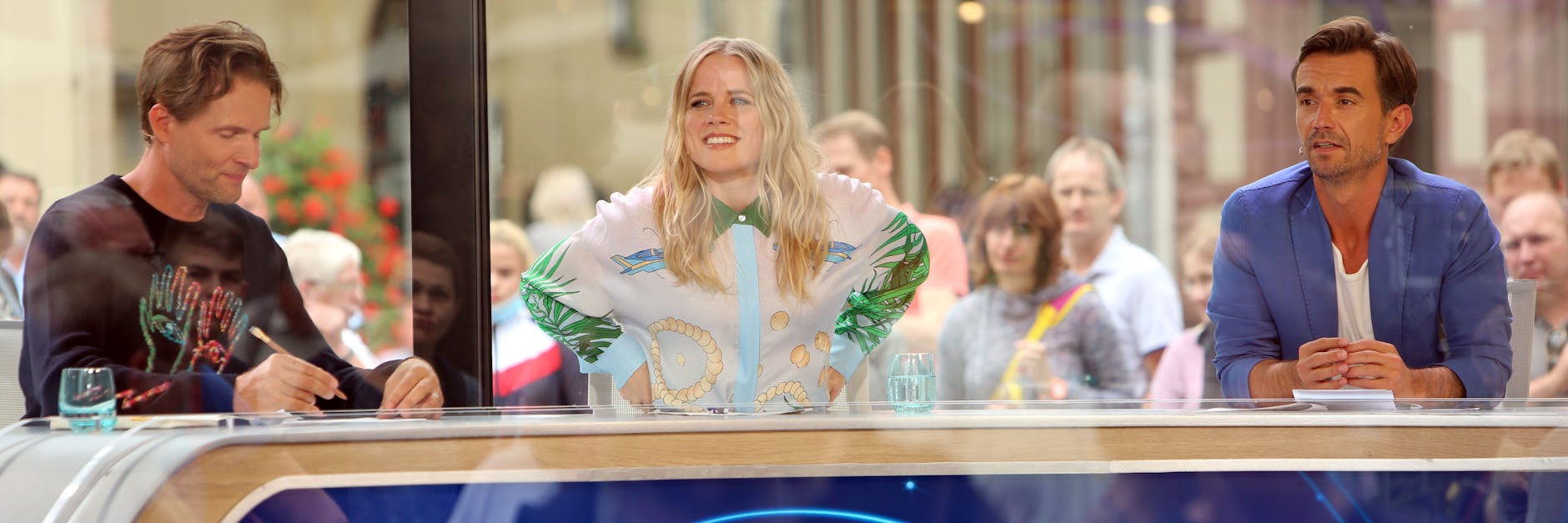 Die Jury von „Deutschland sucht den Superstar“ im Container auf dem Marktplatz von Wernigerode, im Hintergrund glotzen Touristen ins Glashaus.