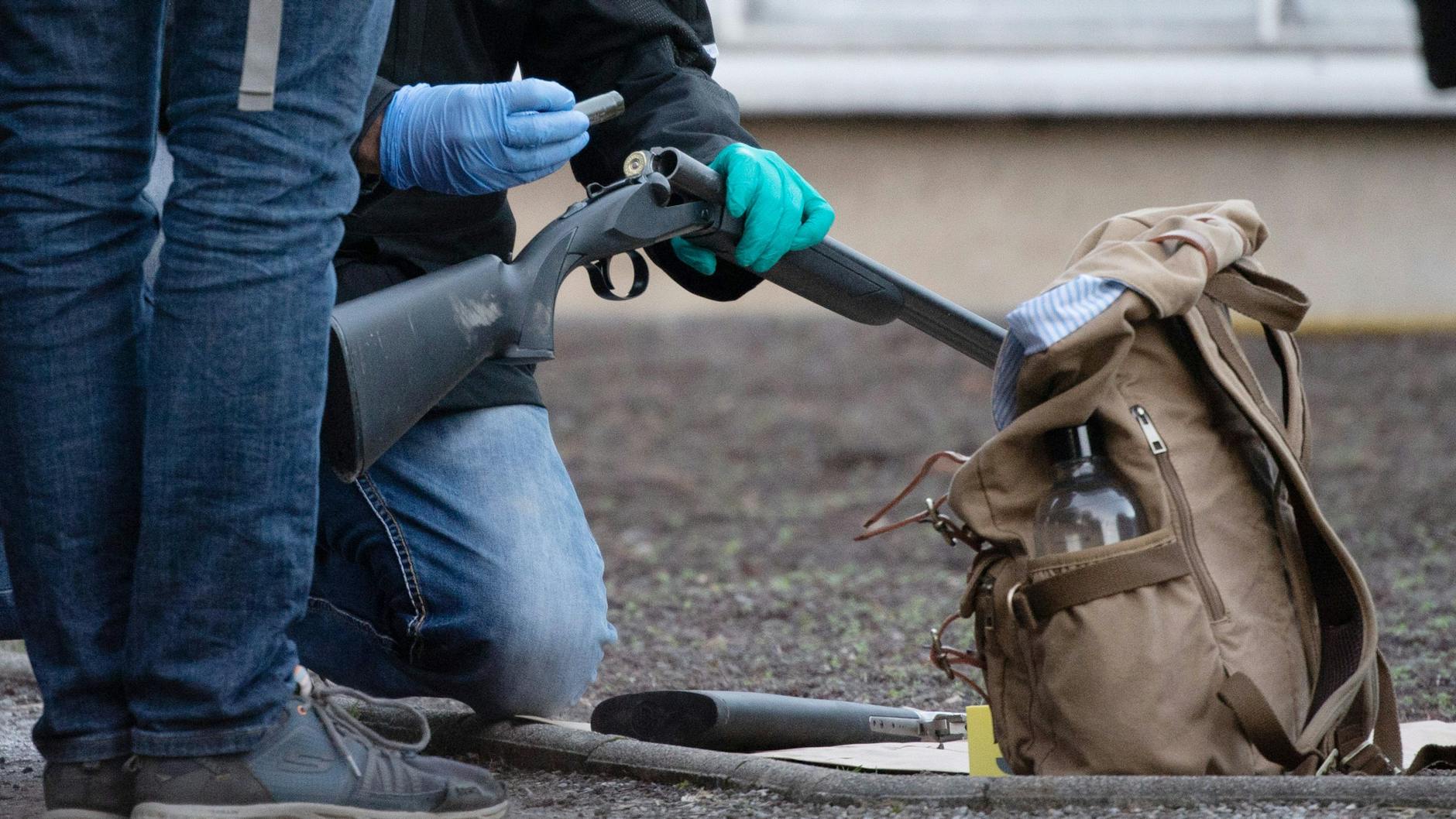 Polizeibeamte untersuchen eine Waffe am Gelände der Heidelberger Universität.