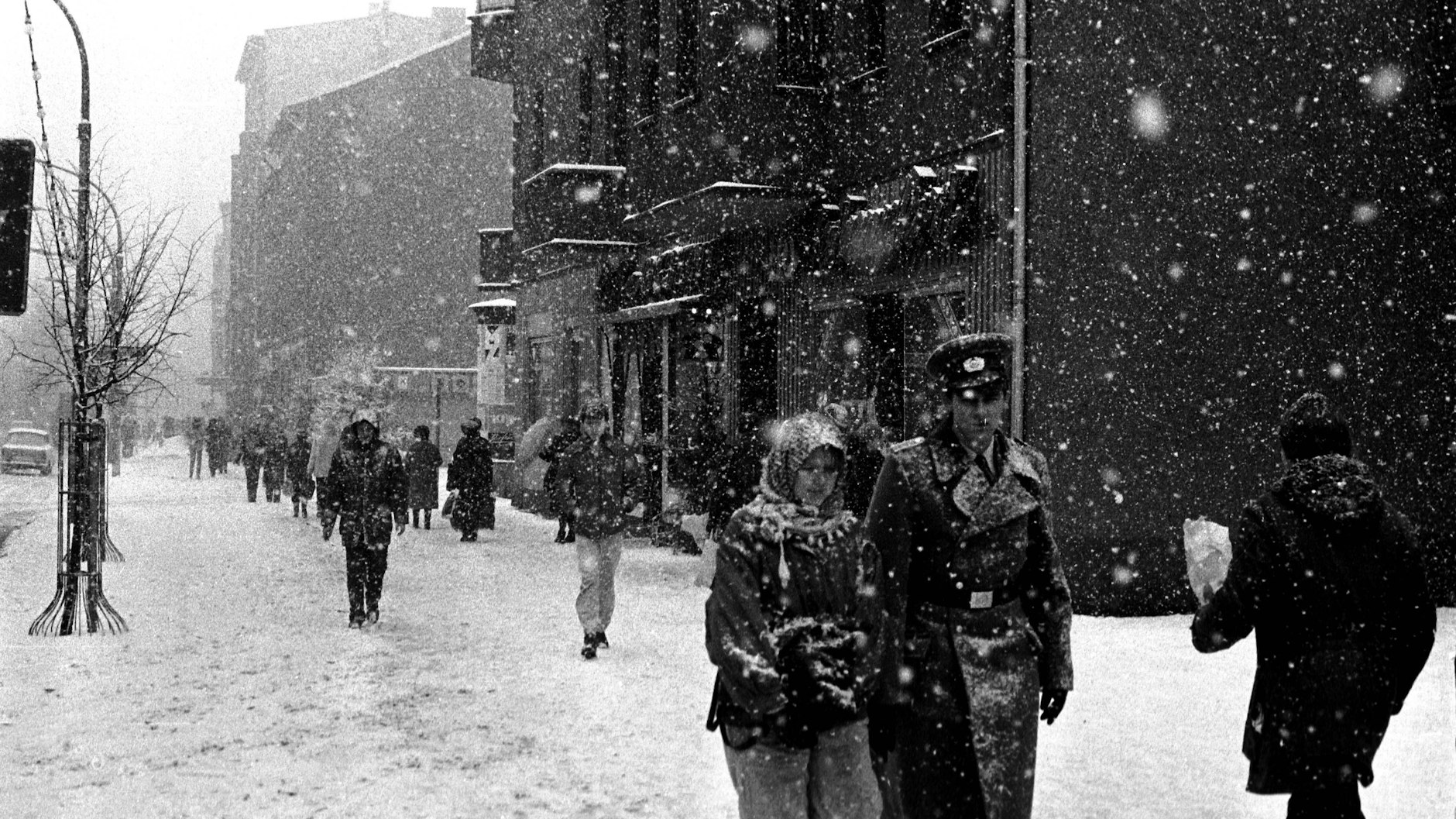 NVA-Soldat mit Freundin in Berlin-Prenzlauer Berg unterwegs im Schneetreiben bei eisigen Temperaturen im Januar 1987.