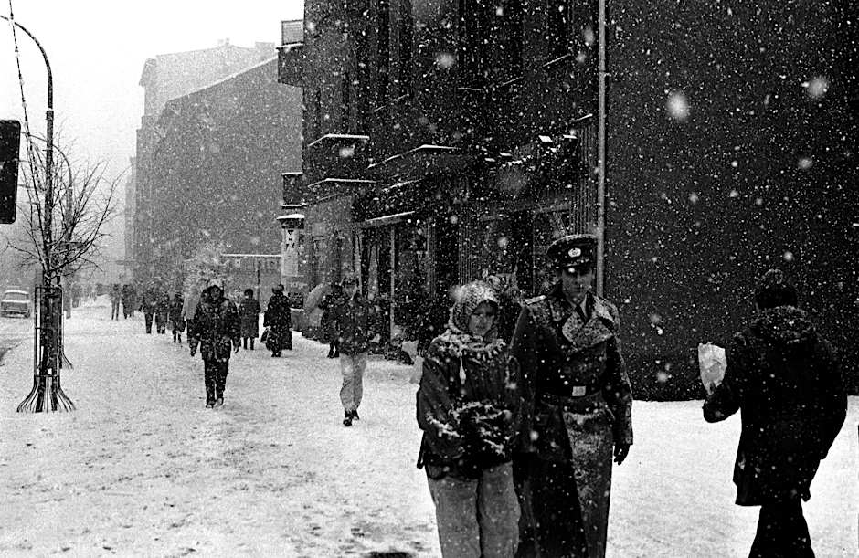 NVA-Soldat mit Freundin in Berlin-Prenzlauer Berg unterwegs im Schneetreiben bei eisigen Temperaturen im Januar 1987.