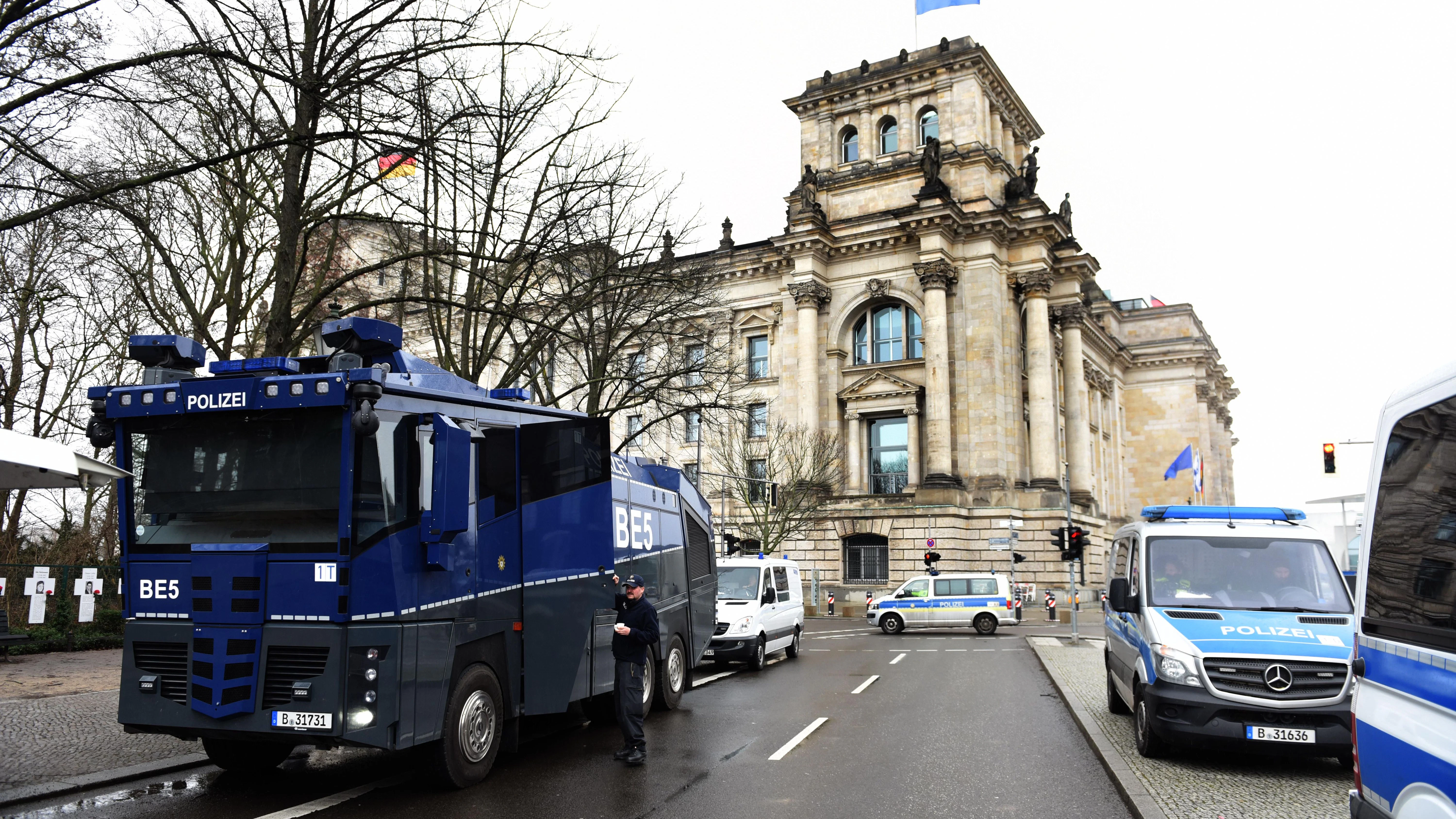 Mit Polizeiabsperrungen und Wasserwerfern wird am Morgen vor der Orientierungsdebatte zu einer SARS-CoV-2-Impfpflicht im Bundestag das Reichstagsgebäude gesichert.  
              
              