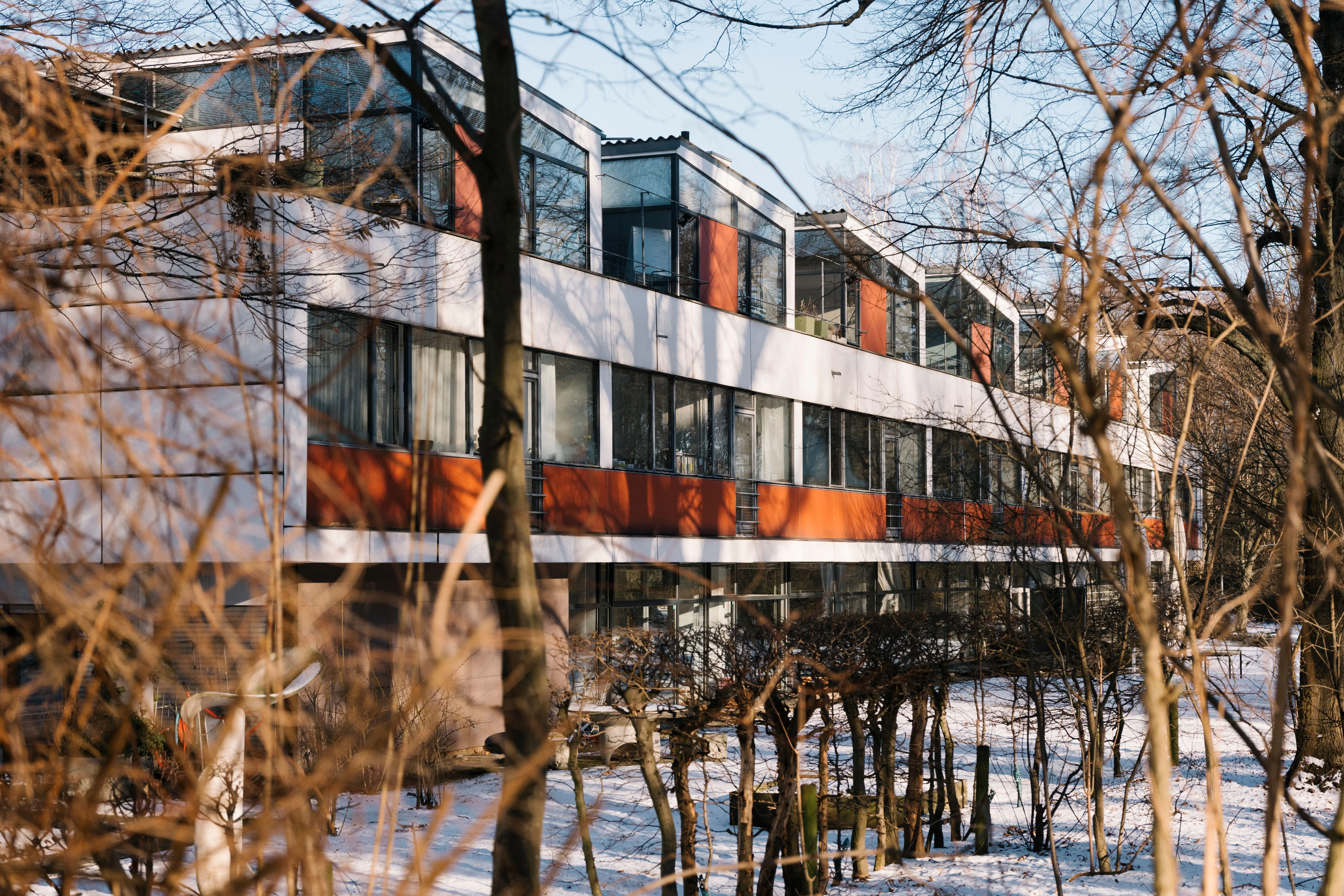 Steht langgezogen zwischen den Bäumen angrenzender Parks: das schiffsähnliche Eternithaus.
