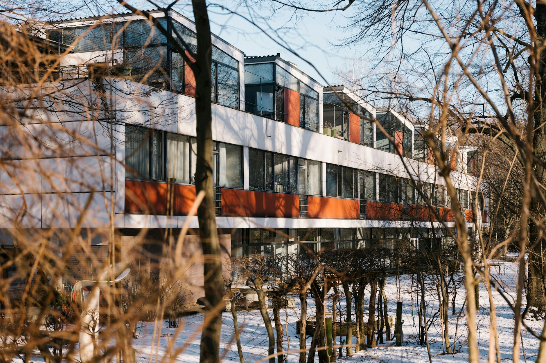 Steht langgezogen zwischen den Bäumen angrenzender Parks: das schiffsähnliche Eternithaus.