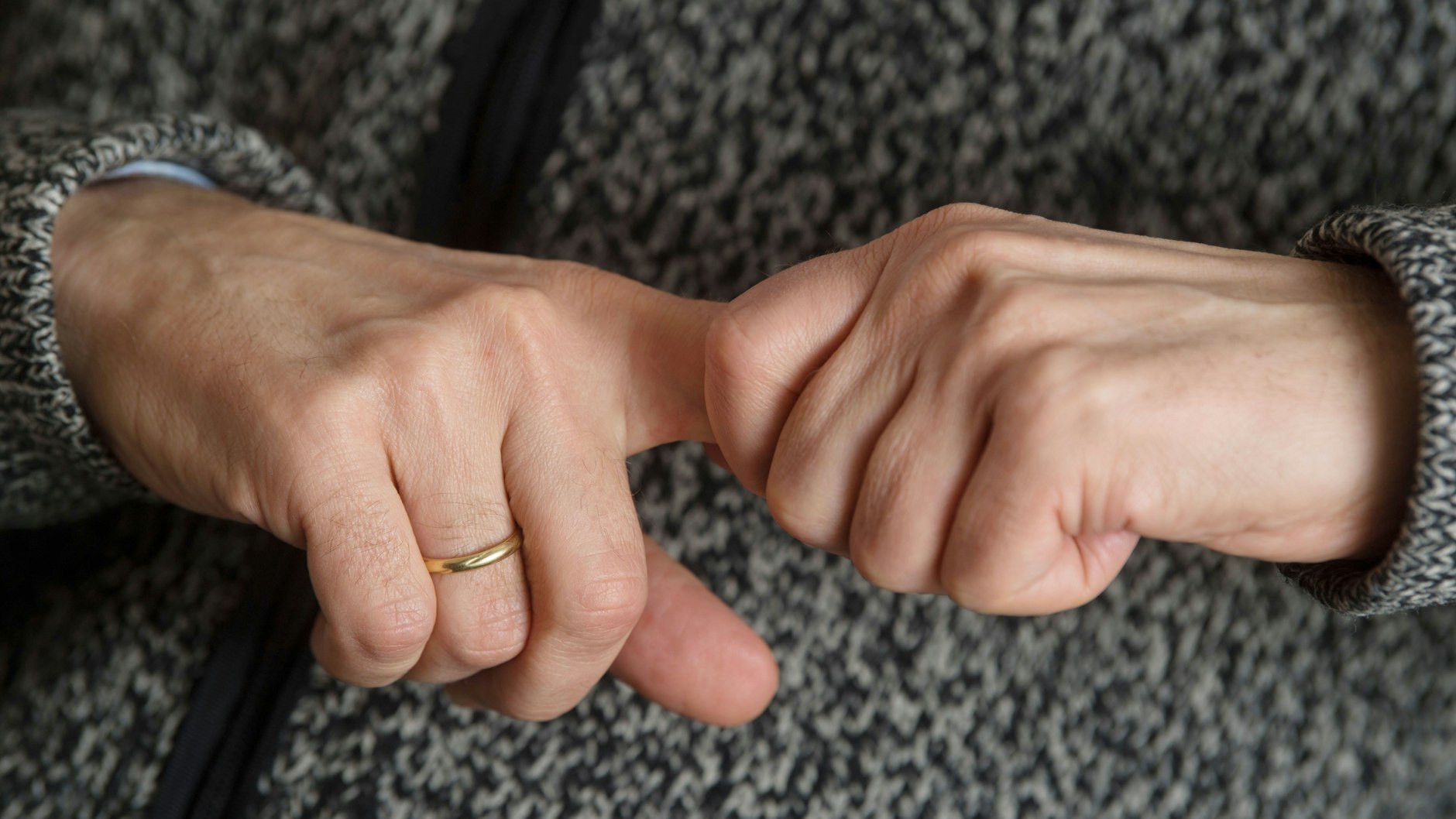 Ein Mann versucht, seine Fingergelenke knacken zu lassen.