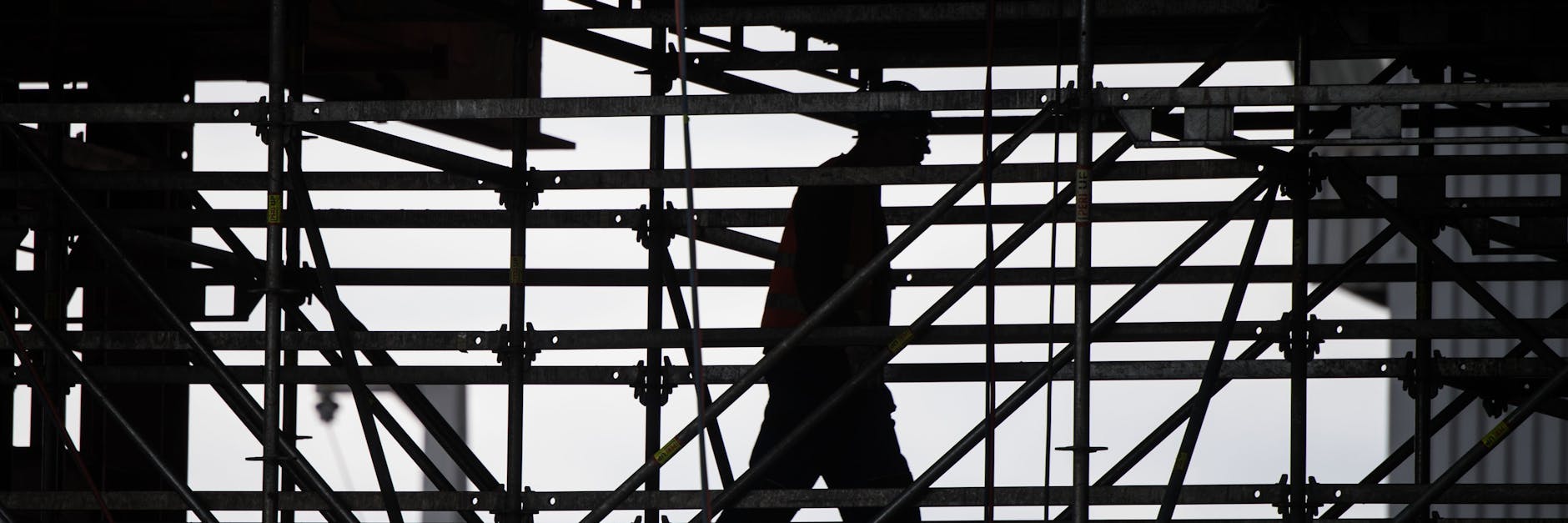 Ein Bauarbeiter geht über ein Gerüst an einer Brückenbaustelle. Berlins Bauarbeiter bekommen eine Corona-Prämie.