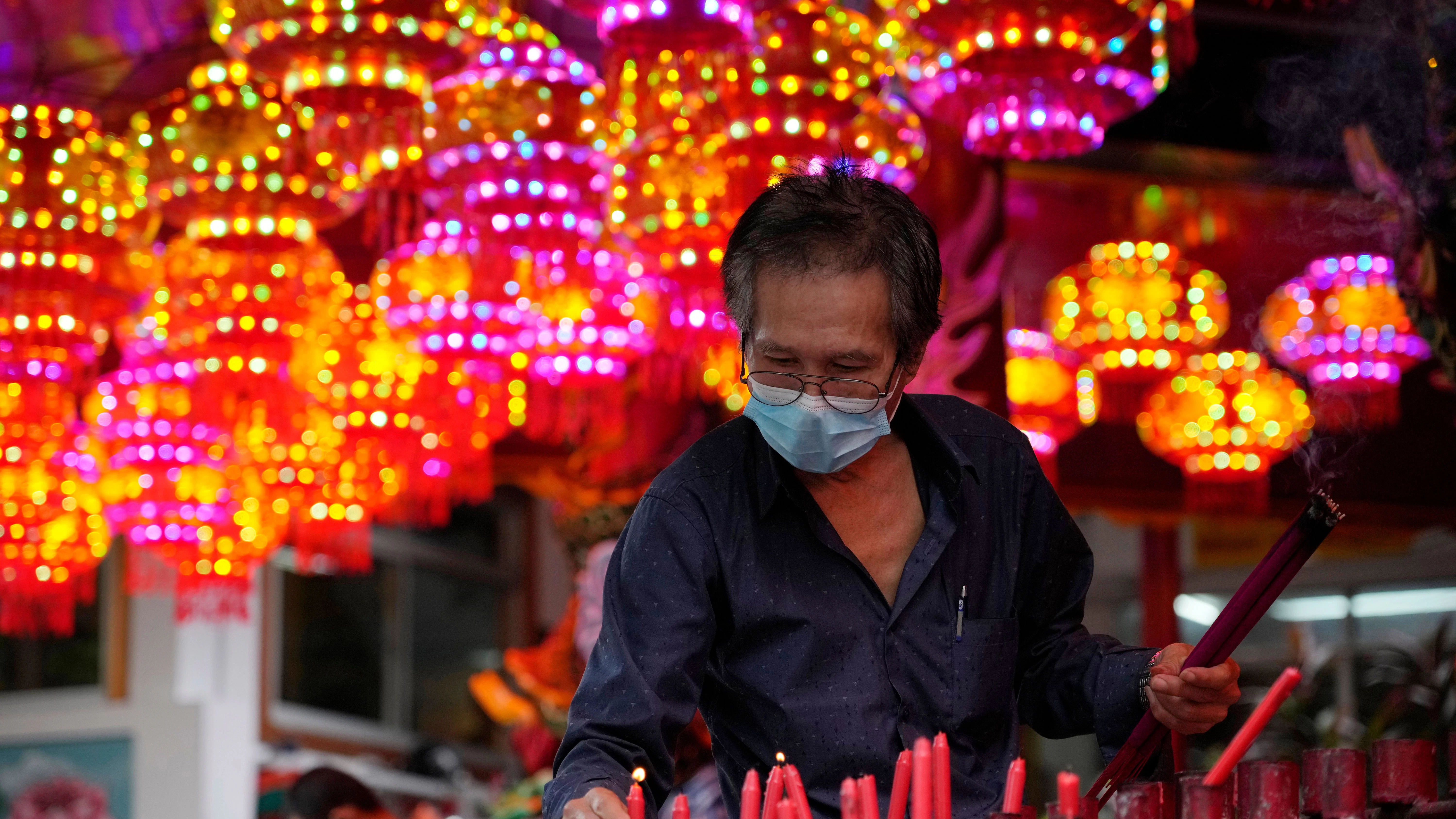 Ein Gläubiger stellt eine brennende Kerze anlässlich des chinesischen Neujahrsfests auf.