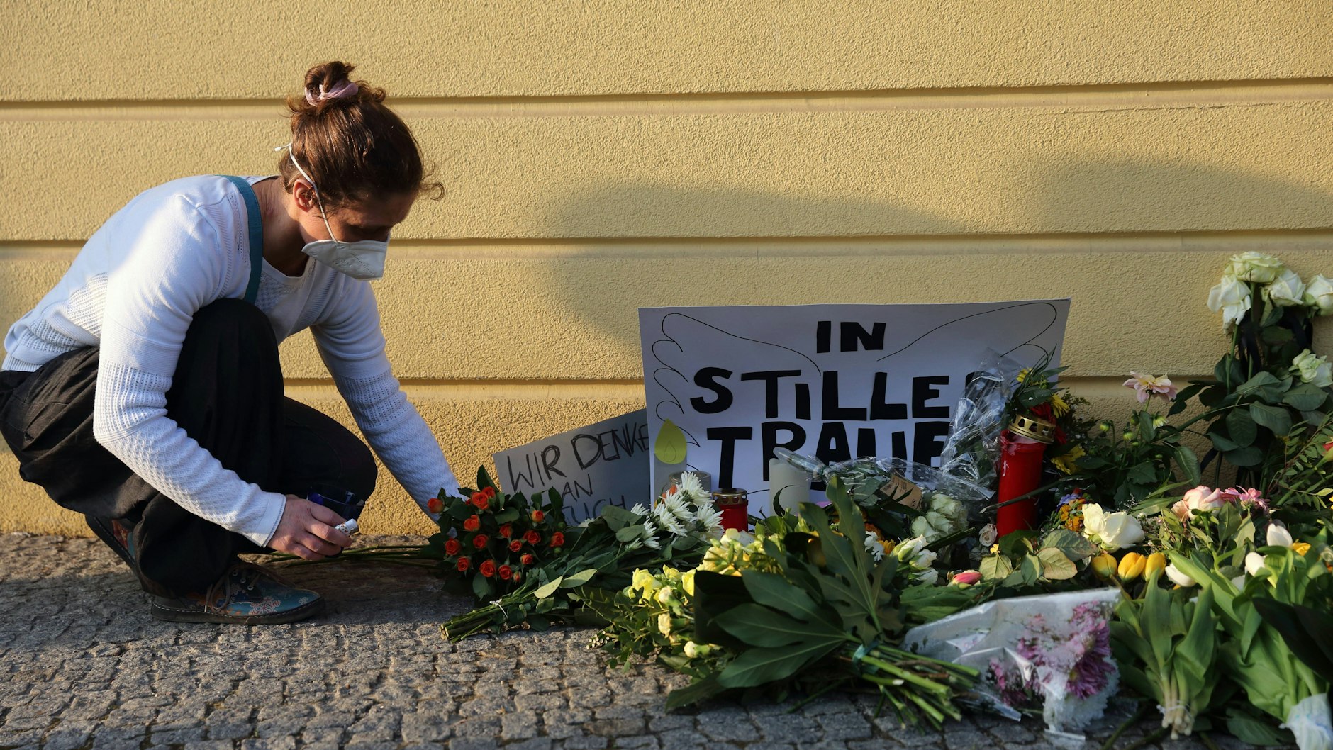 Eine Frau legt kurz nach der Tat im April 2021 Blumen nieder und gedenkt der Opfer am Babelsberger Oberlinhaus, wo vier behinderte Menschen gewaltsam getötet worden.