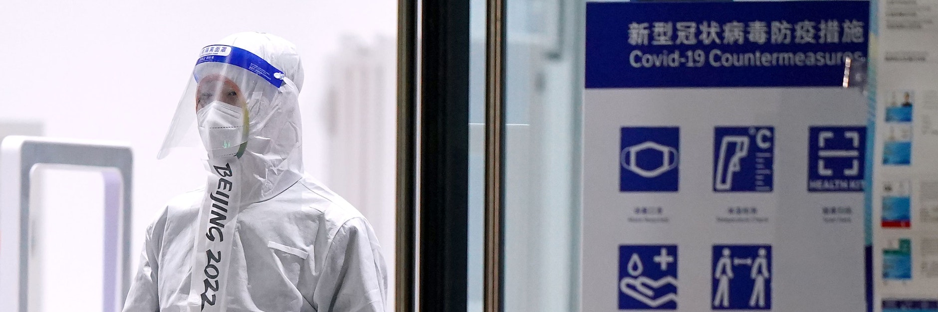 Ein Olympia-Mitarbeiter mit Schutzkleidung. So sehen die Corona-Kontrollen in Peking aus.