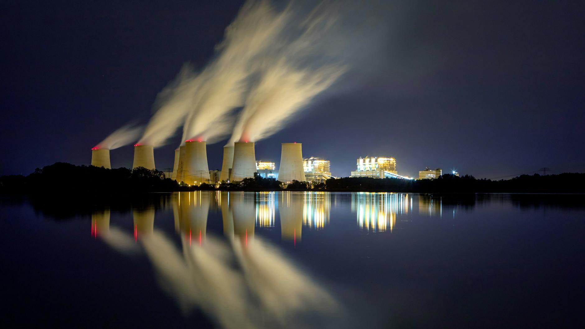 Das Braunkohlekraftwerk Jänschwalde spiegelt sich in den Peitzer Teichen.