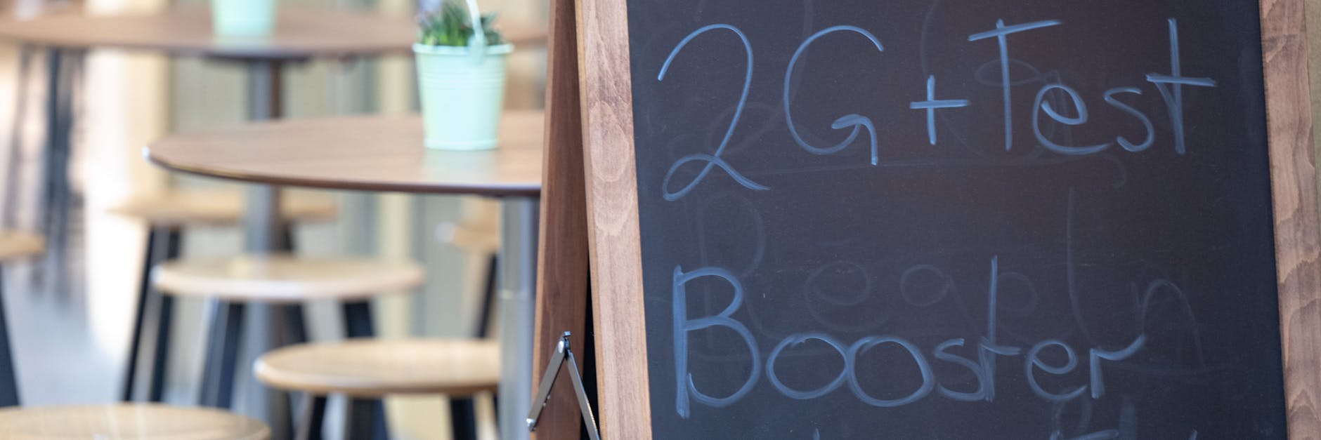 Ein Hinweisschild für die 2G plus Regel steht vor einem Restaurant in der Innenstadt von Stuttgart.